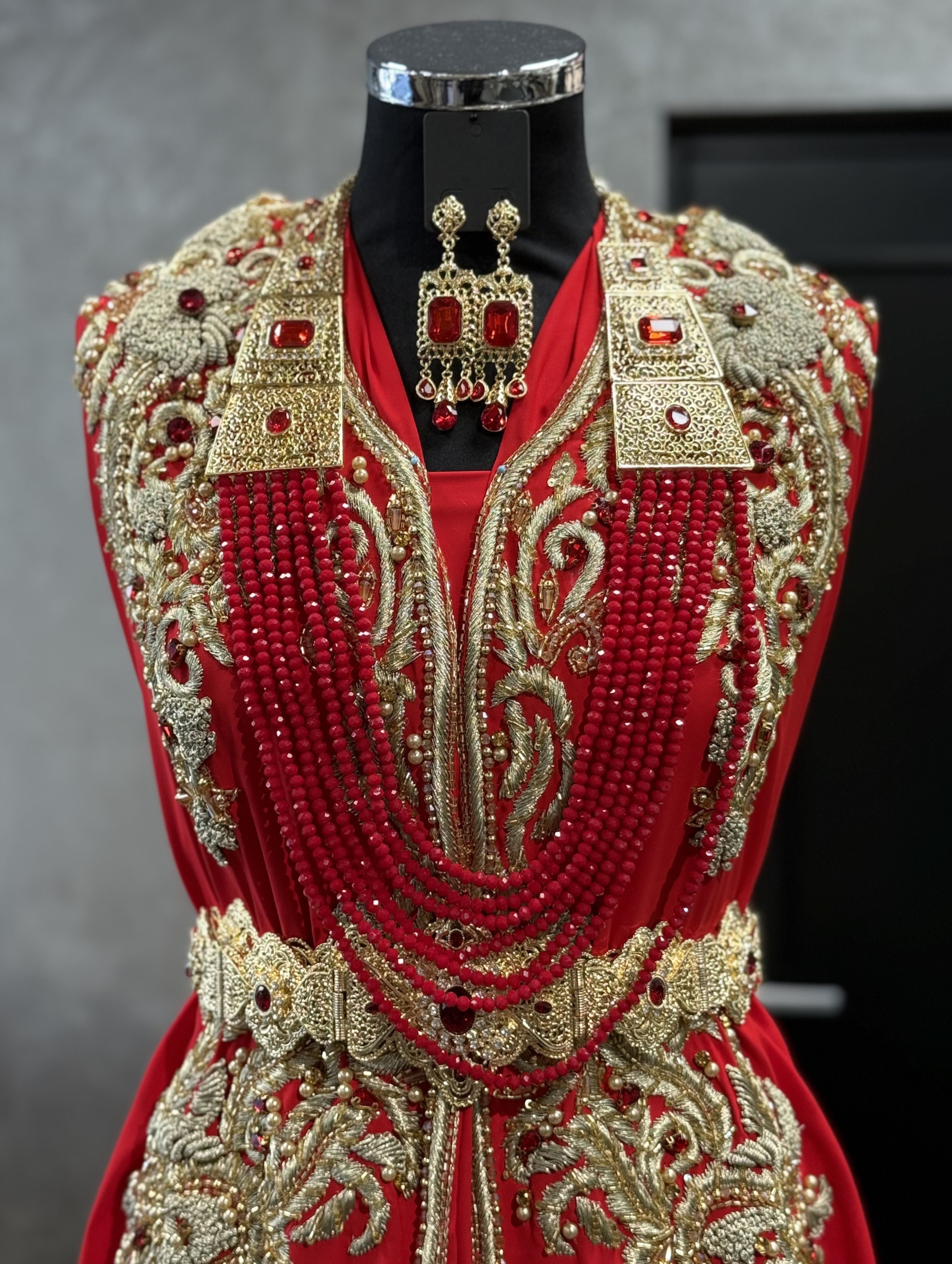 Gouden ketting met rode stenen en meerdere lagen kralen met bijpassende oorbellen