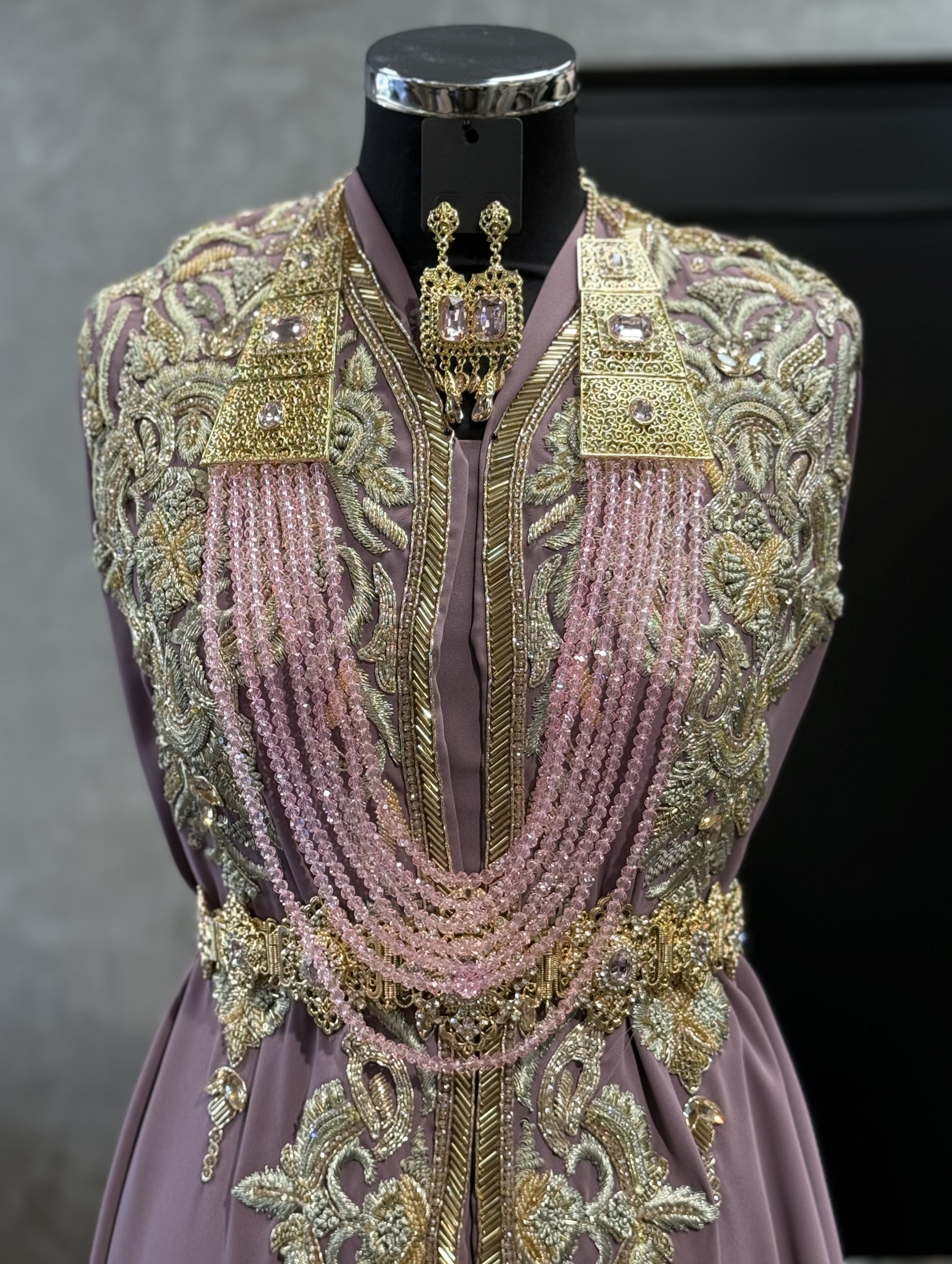 Gouden ketting met roze stenen en meerdere lagen kralen met bijpassende oorbellen