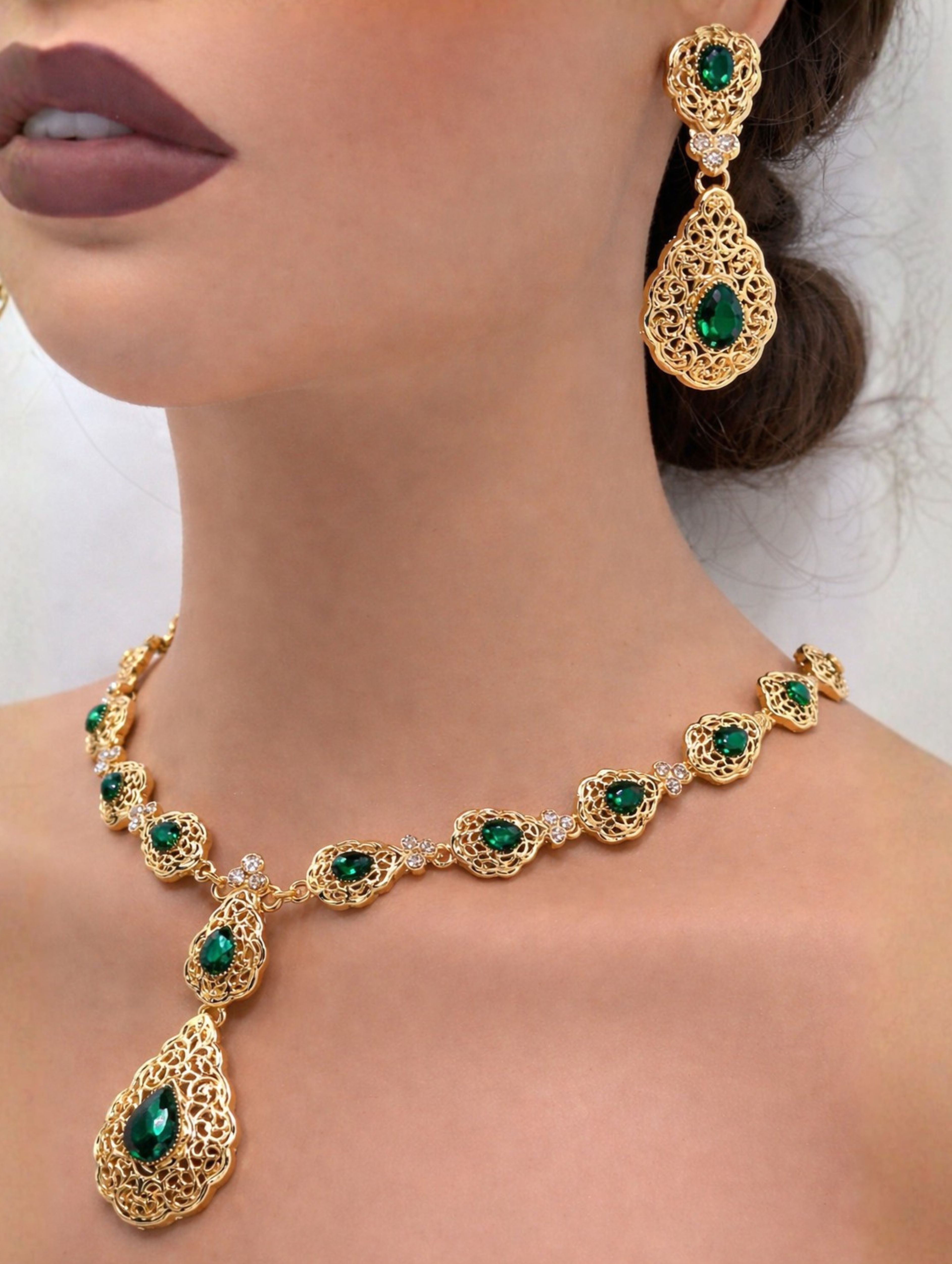 Elegante gouden ketting met oorbellen met smaragdgroene stenen, ideaal bij een takshita of feestelijke outfit.