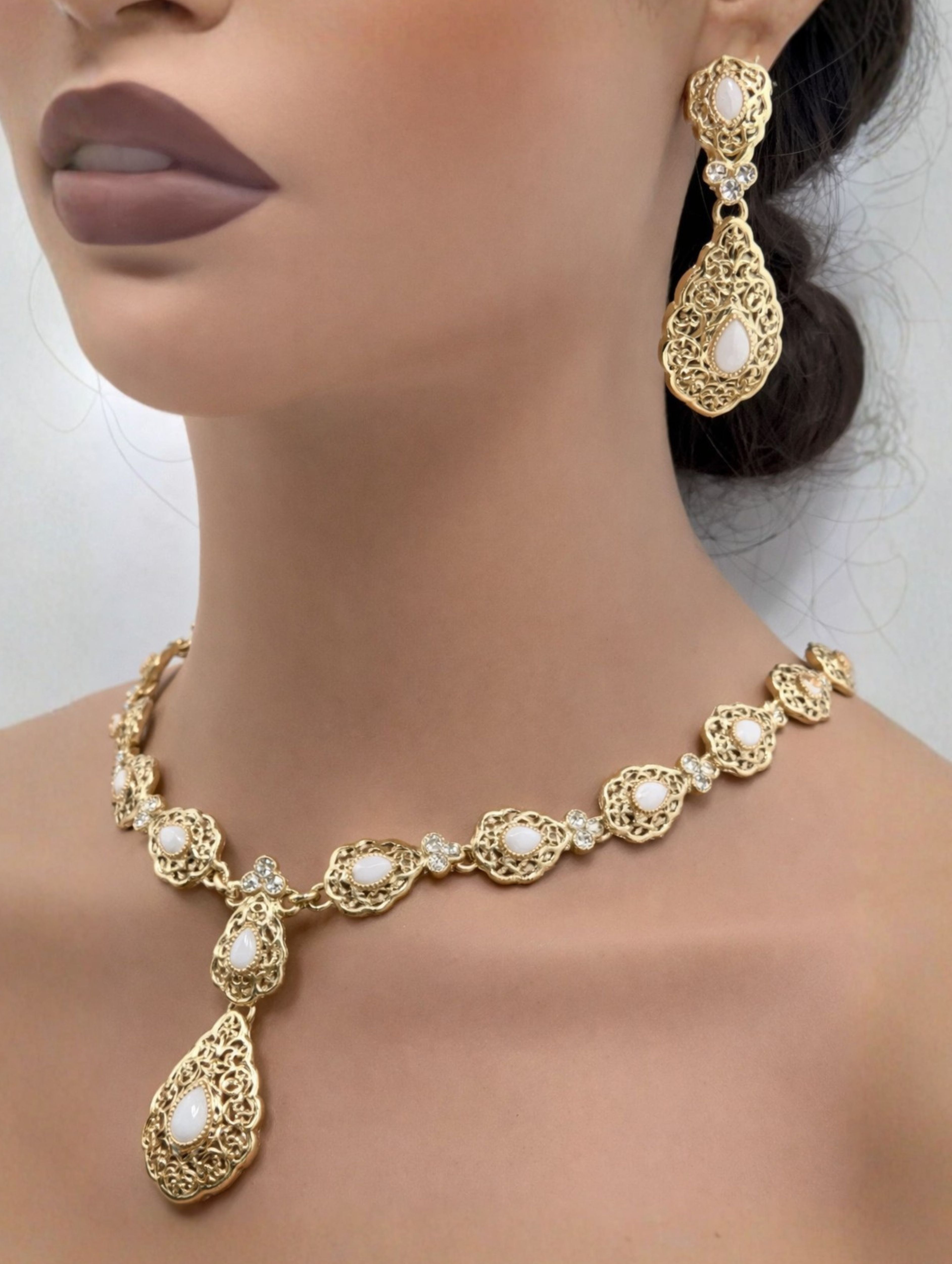 Elegante gouden ketting met oorbellen met witte stenen, ideaal bij een takshita of feestelijke outfit.
