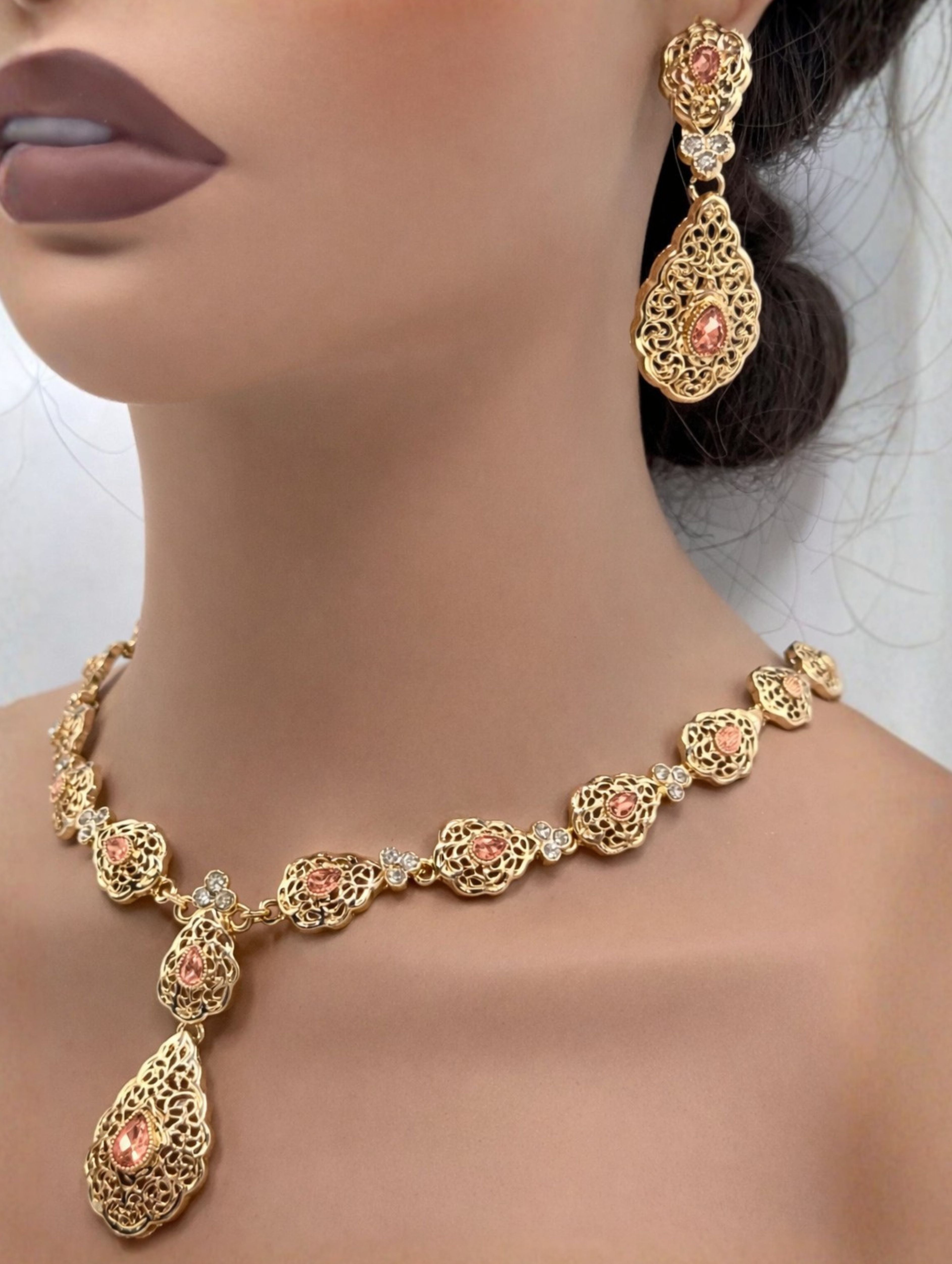 Elegante gouden ketting met oorbellen met zalmkleurige stenen, ideaal bij een takshita of feestelijke outfit.