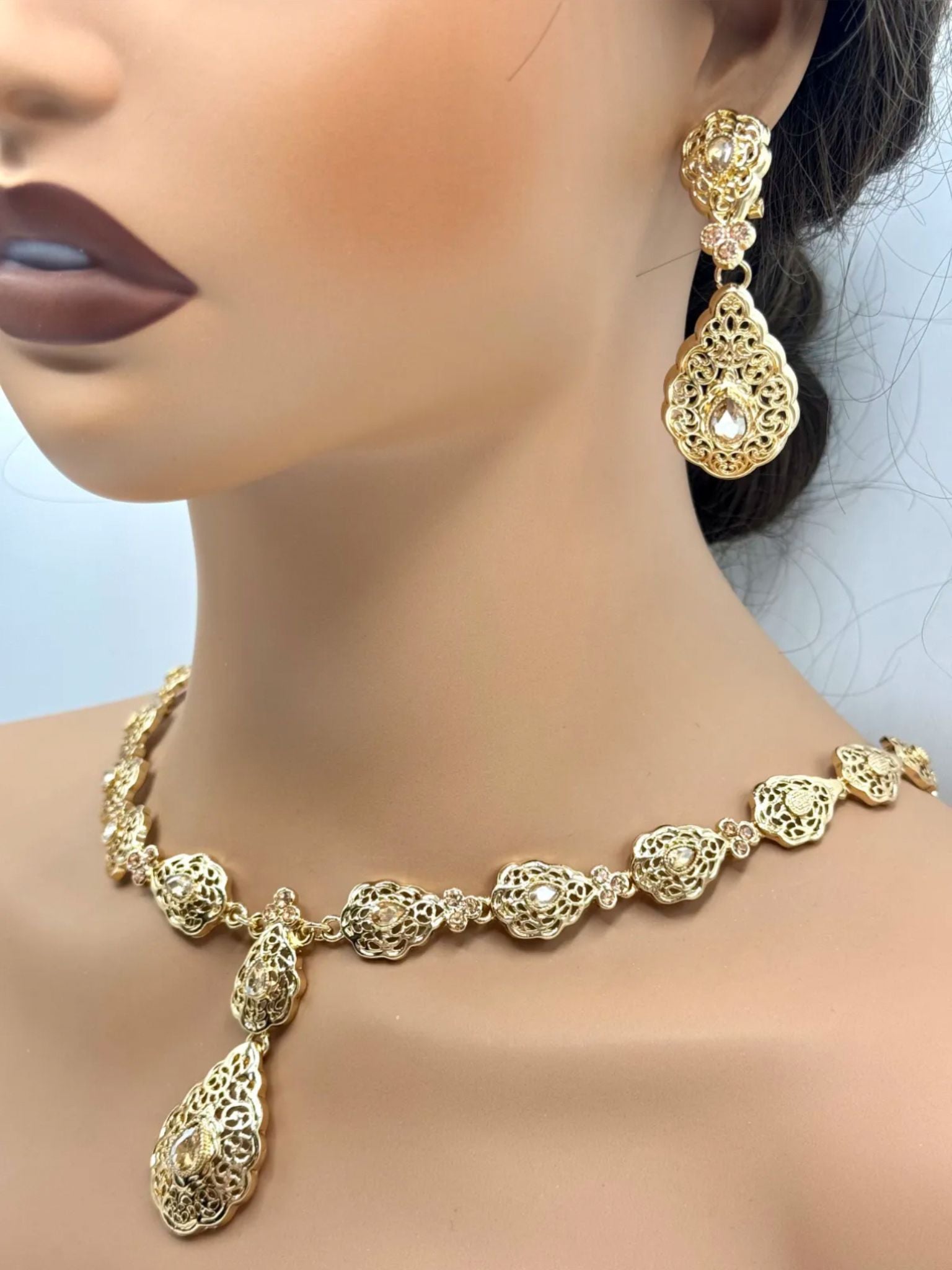 Elegante gouden ketting met bijpassende oorbellen, versierd met fonkelende gouden stenen voor een luxe uitstraling