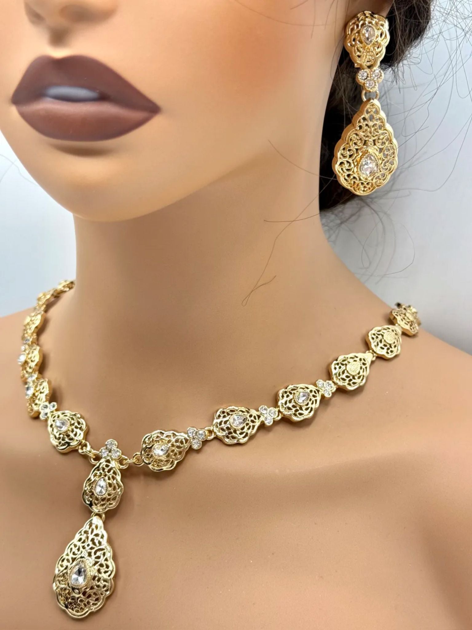 Elegante gouden ketting met bijpassende oorbellen, versierd met fonkelende heldere stenen voor een luxe uitstraling