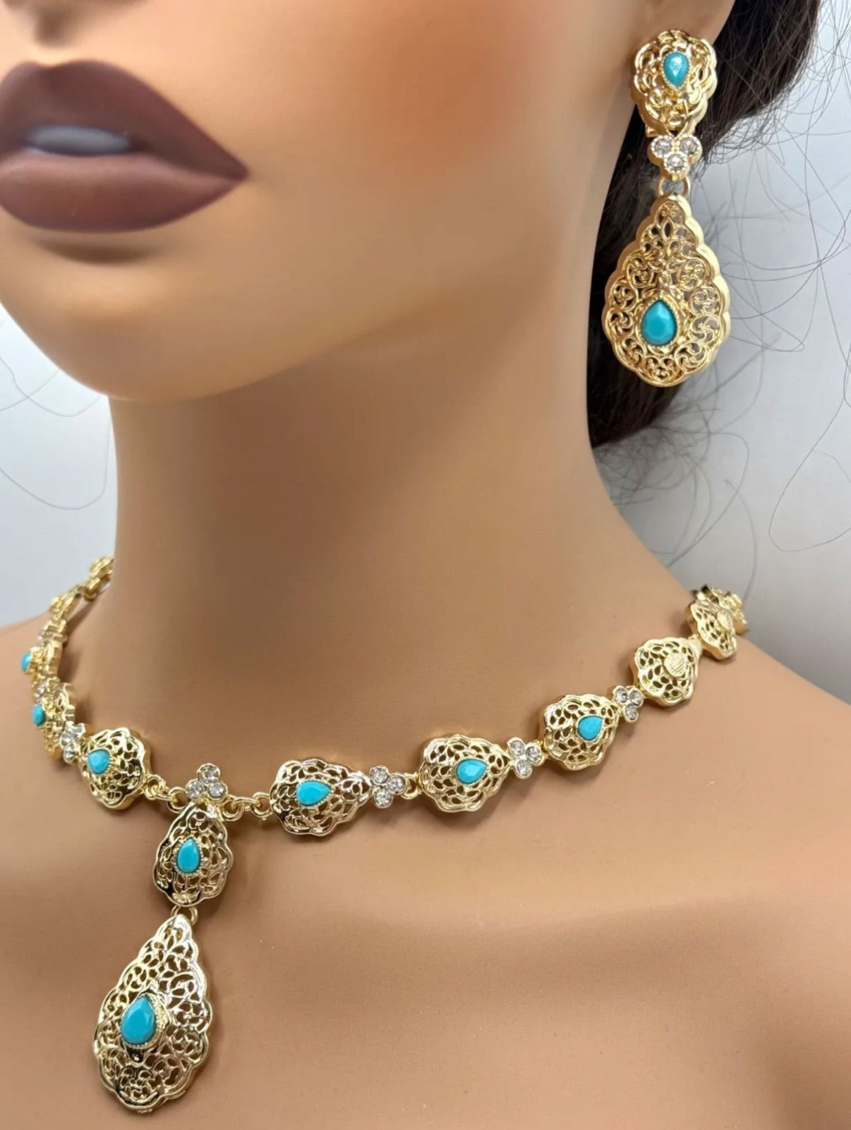 Elegante gouden ketting met bijpassende oorbellen, versierd met fonkelende turquoise stenen voor een luxe uitstraling