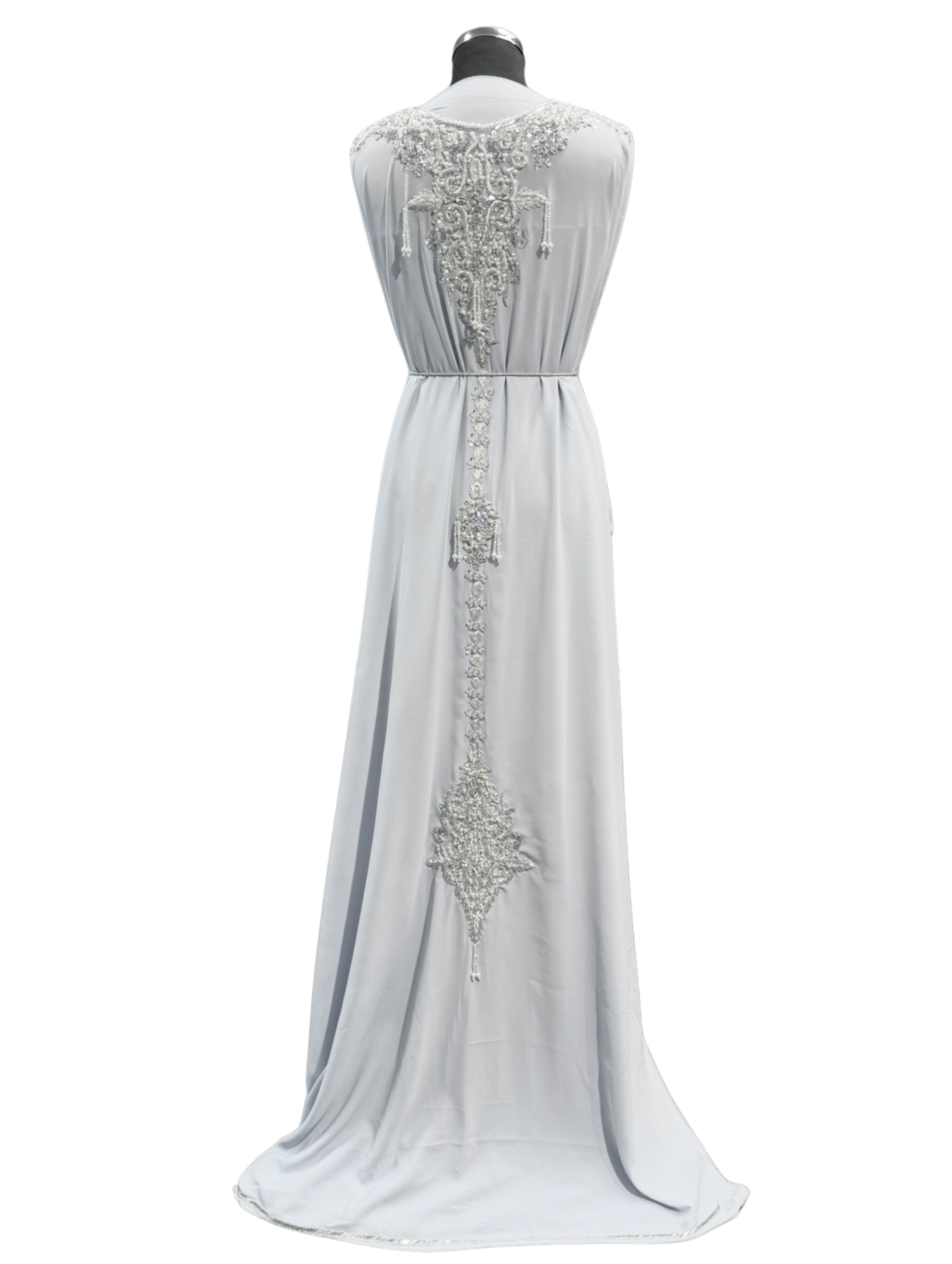 Achterkant van licht grijze caftan of takshita stof met zilveren borduursel, steentjes en parels