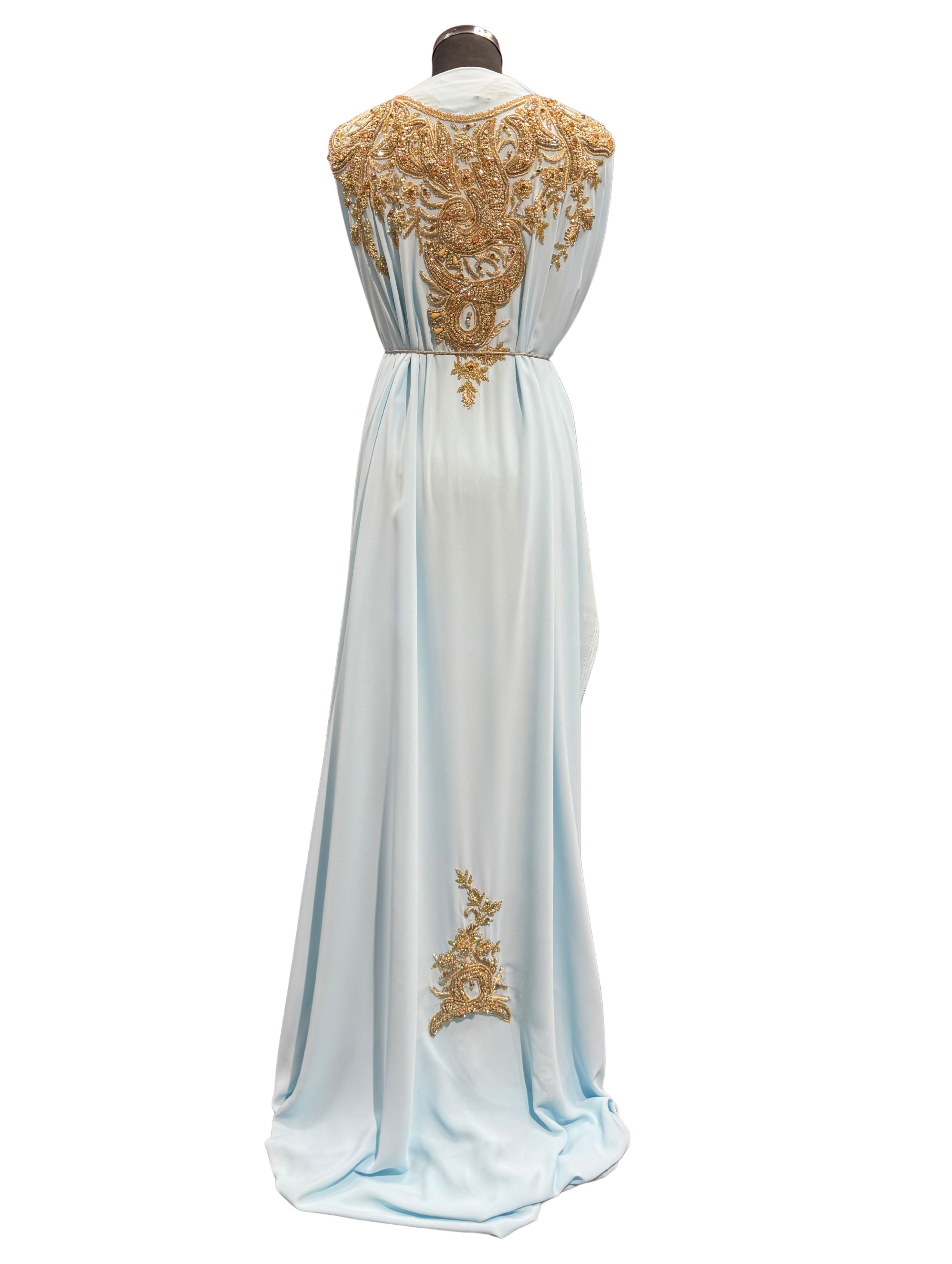 Achterkant van lichtblauwe soepel vallende crêpe stof met kraaltjes en goudkleurig borduurwerk.