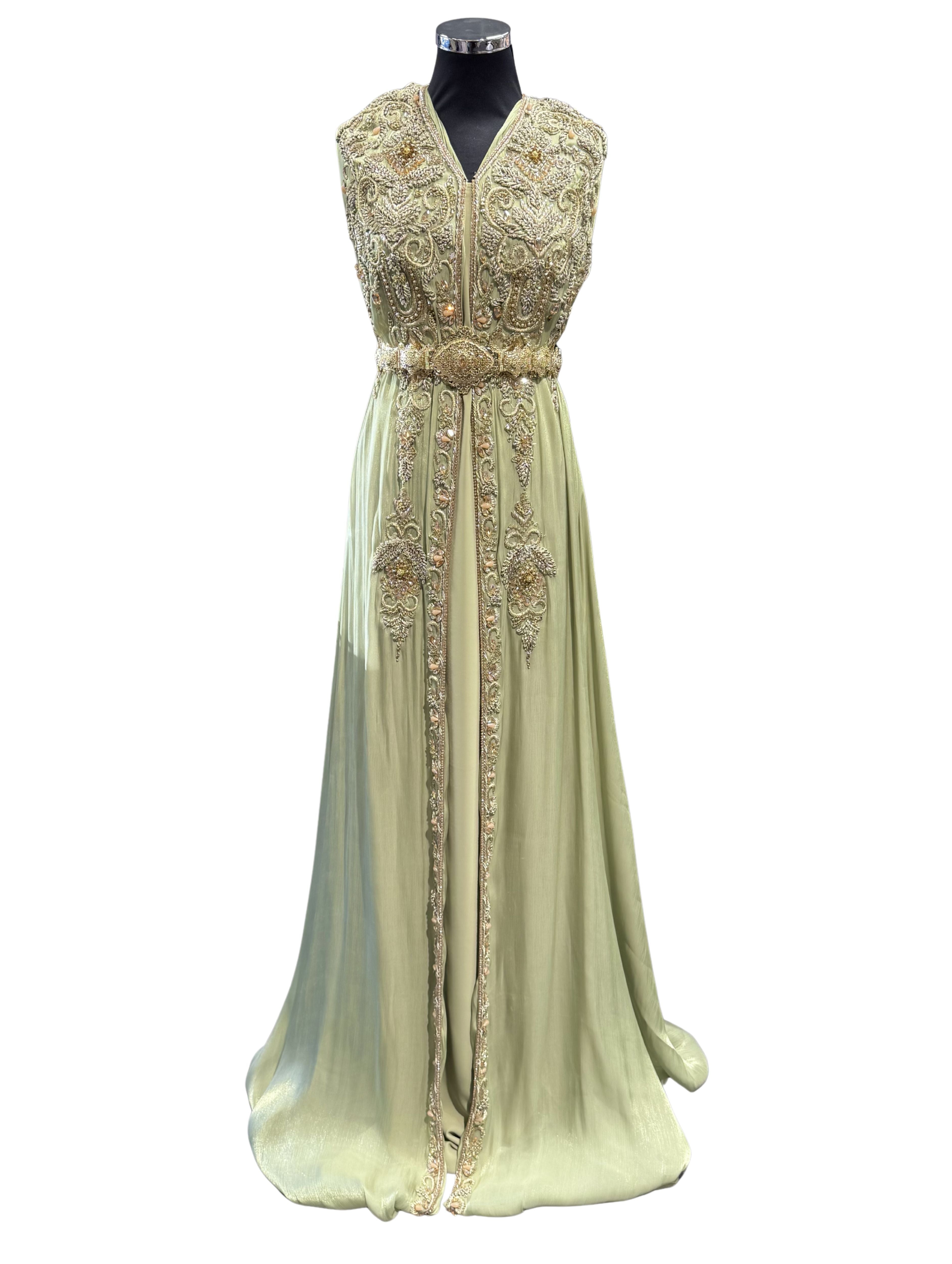 Voorkant van pistache soepel vallende organza stof, bewerkt met steentjes, kralen en een gouden bewerking.