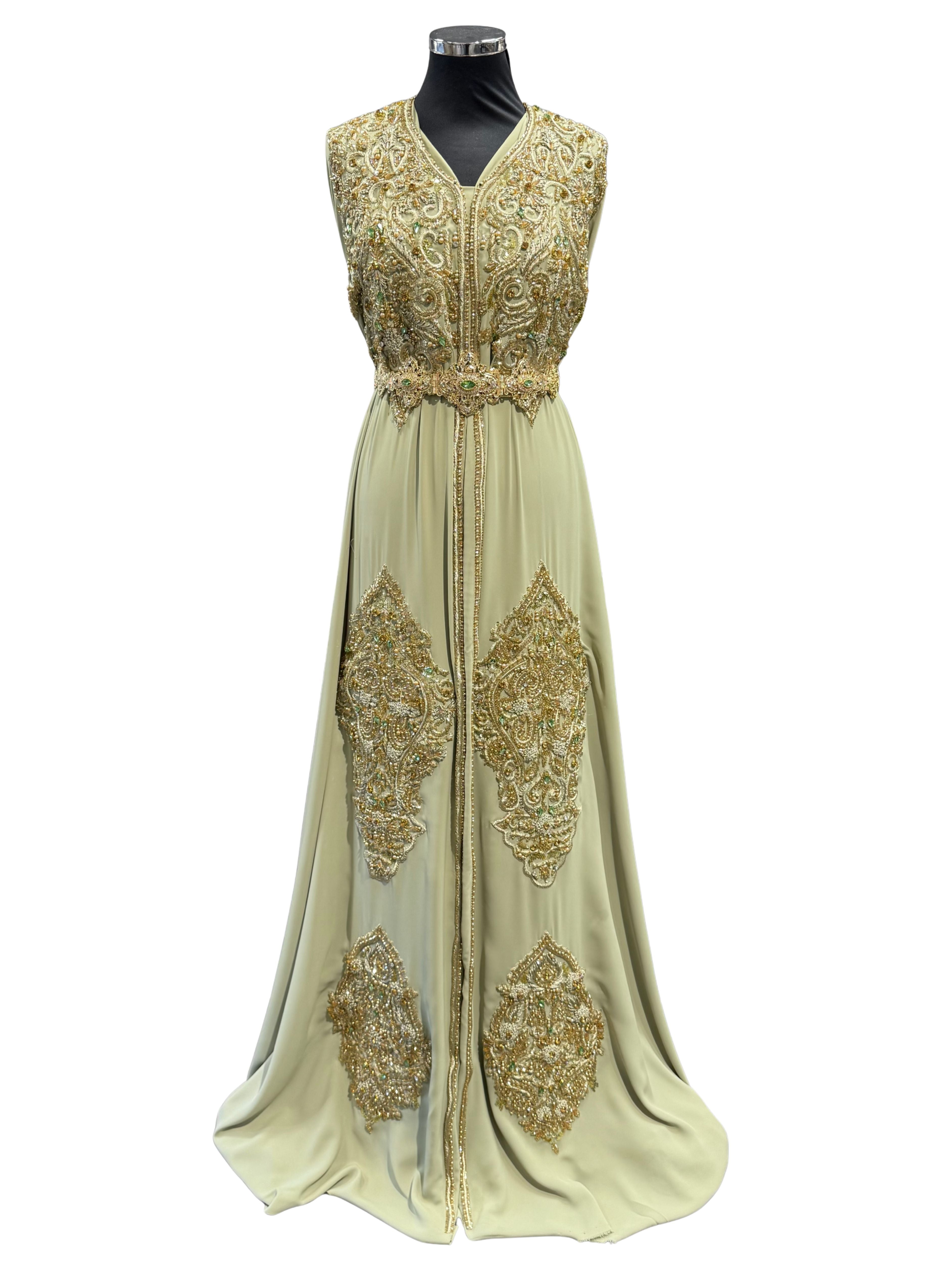 Voorkant van pistache takchita stof van crepe kwaliteit, bewerkt met gouden accenten, glanzende kralen en fonkelende stenen. De onderstof is pistache crepe.