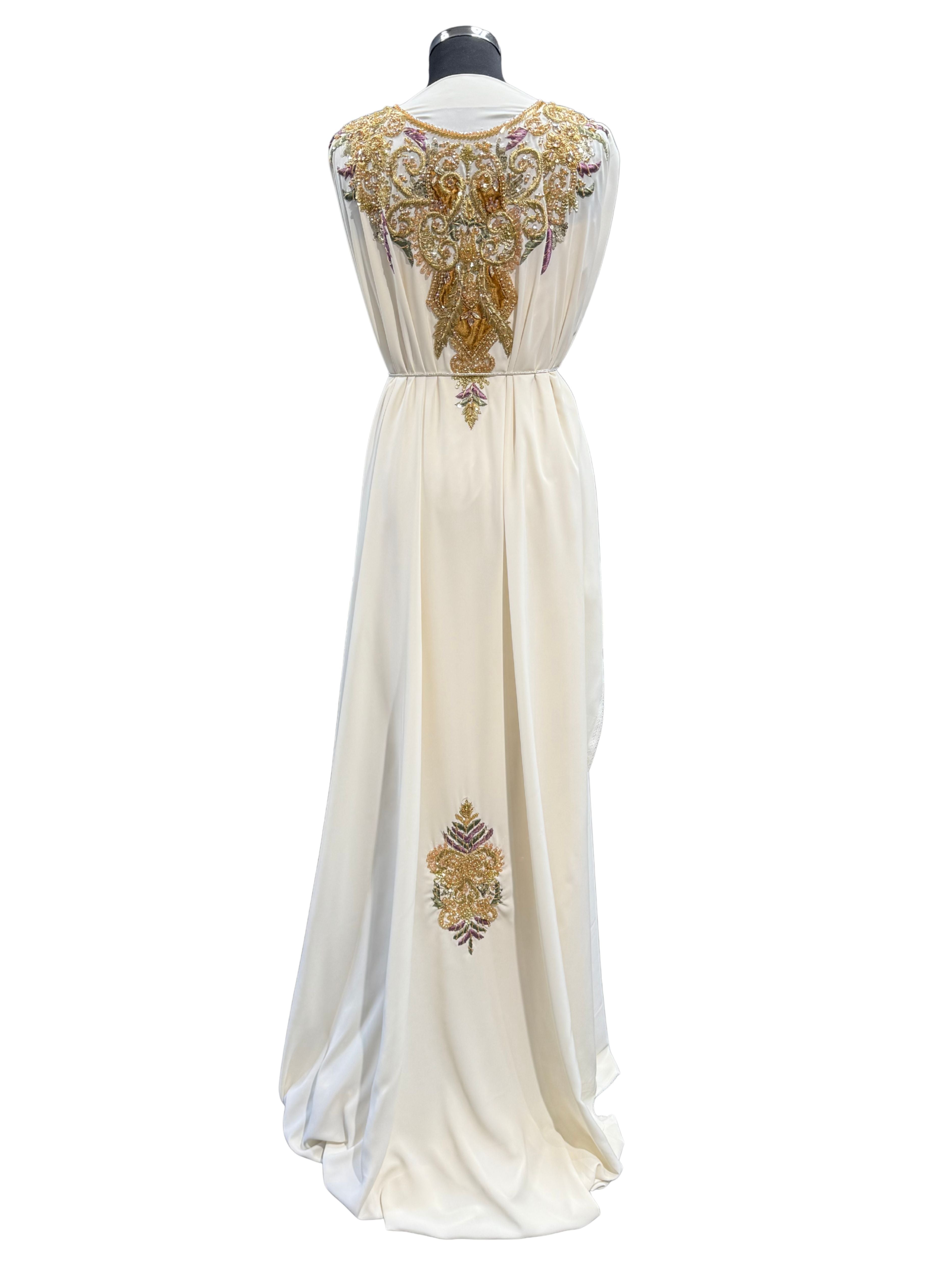 Achterkant van crème takshita stof van crepe kwaliteit, bewerkt met gouden accenten, velours patches en paarse en groene borduurwerk. De onderstof is crème crepe.