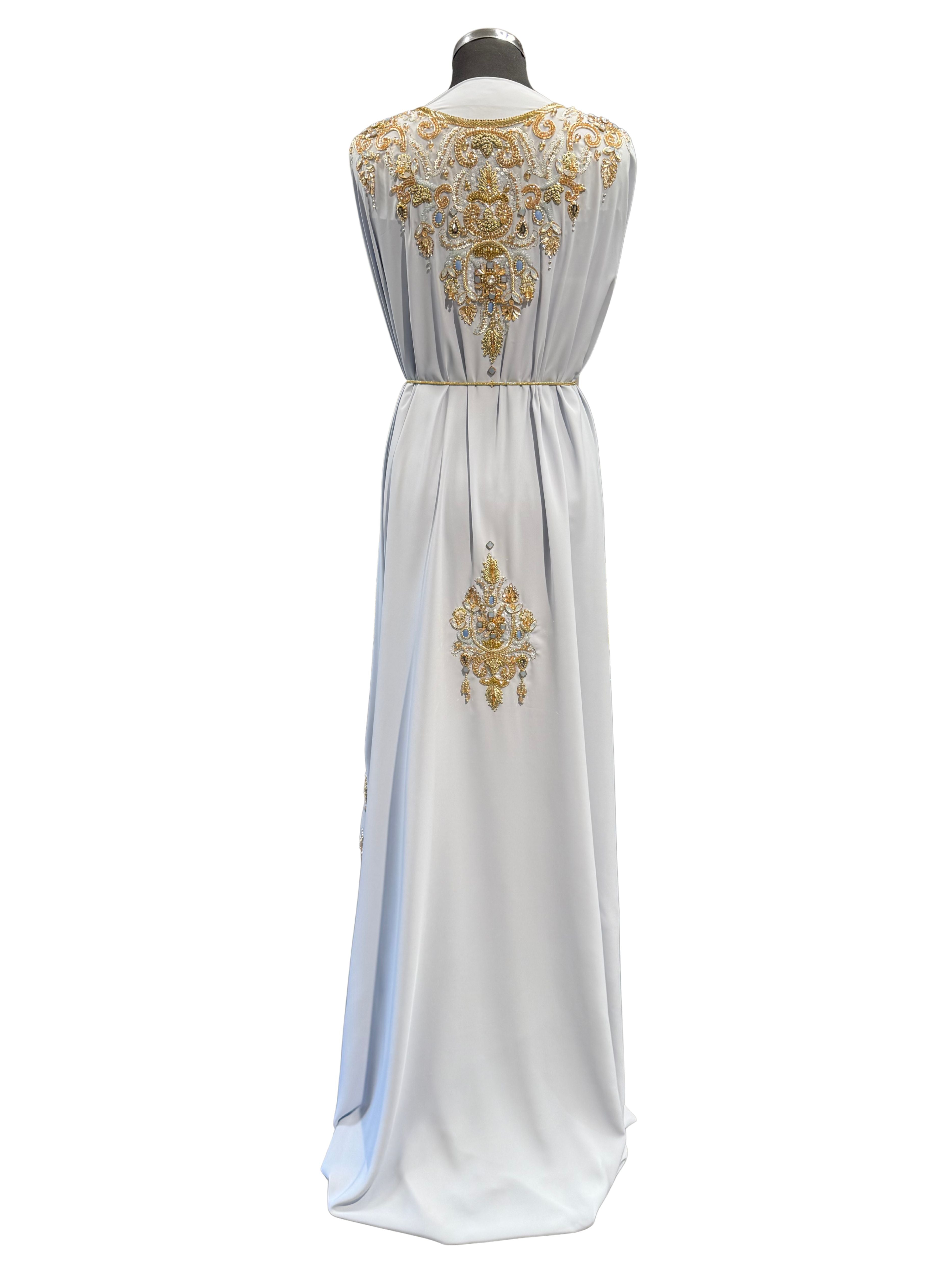 Achterkant van lichtblauwe takshita stof van crepe kwaliteit, verfijnd bewerkt met gouden accenten.
