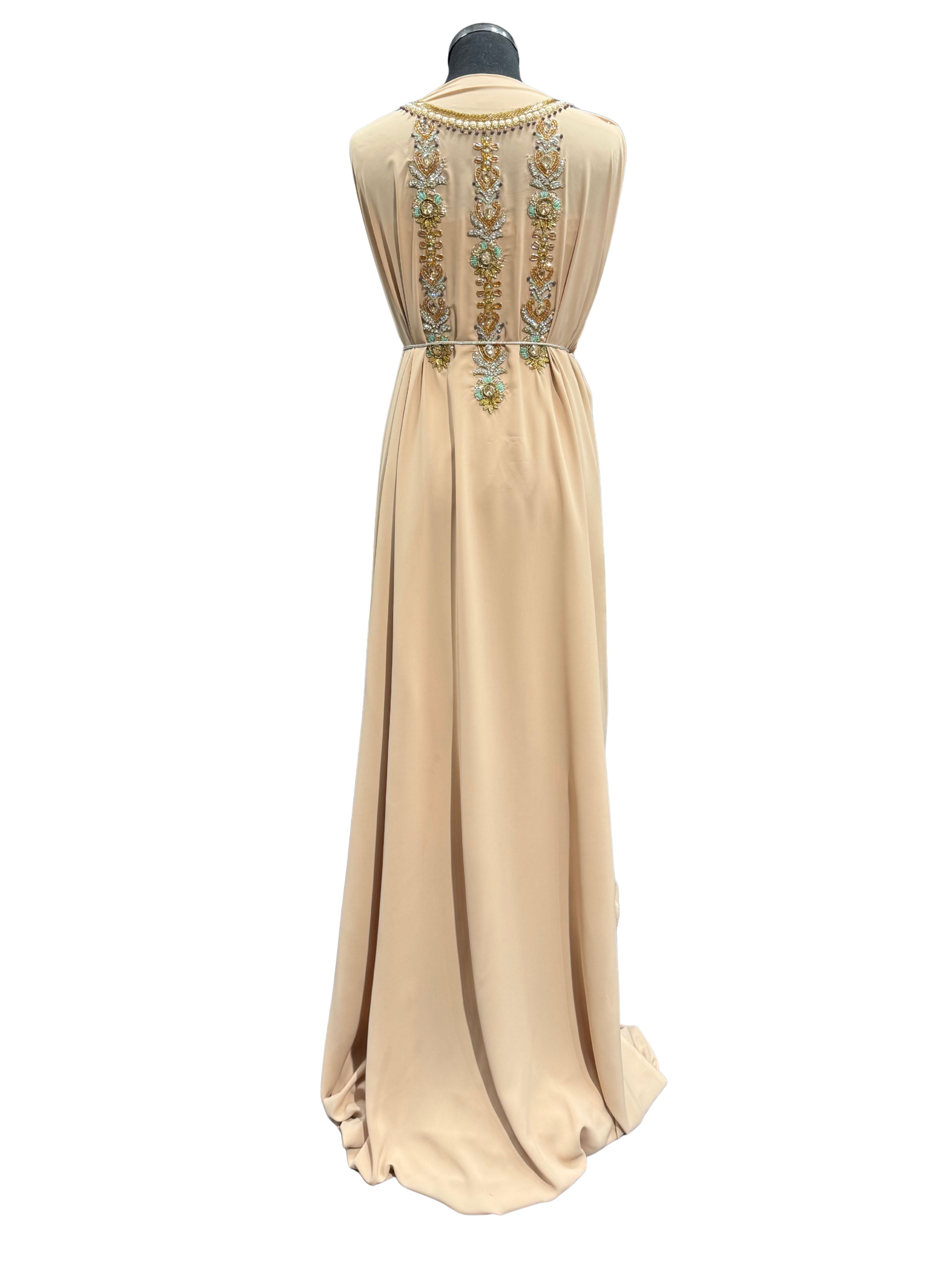 Achterkant van zandbeige takshita stof, subtiel bewerkt met kraaltjes en steentjes.