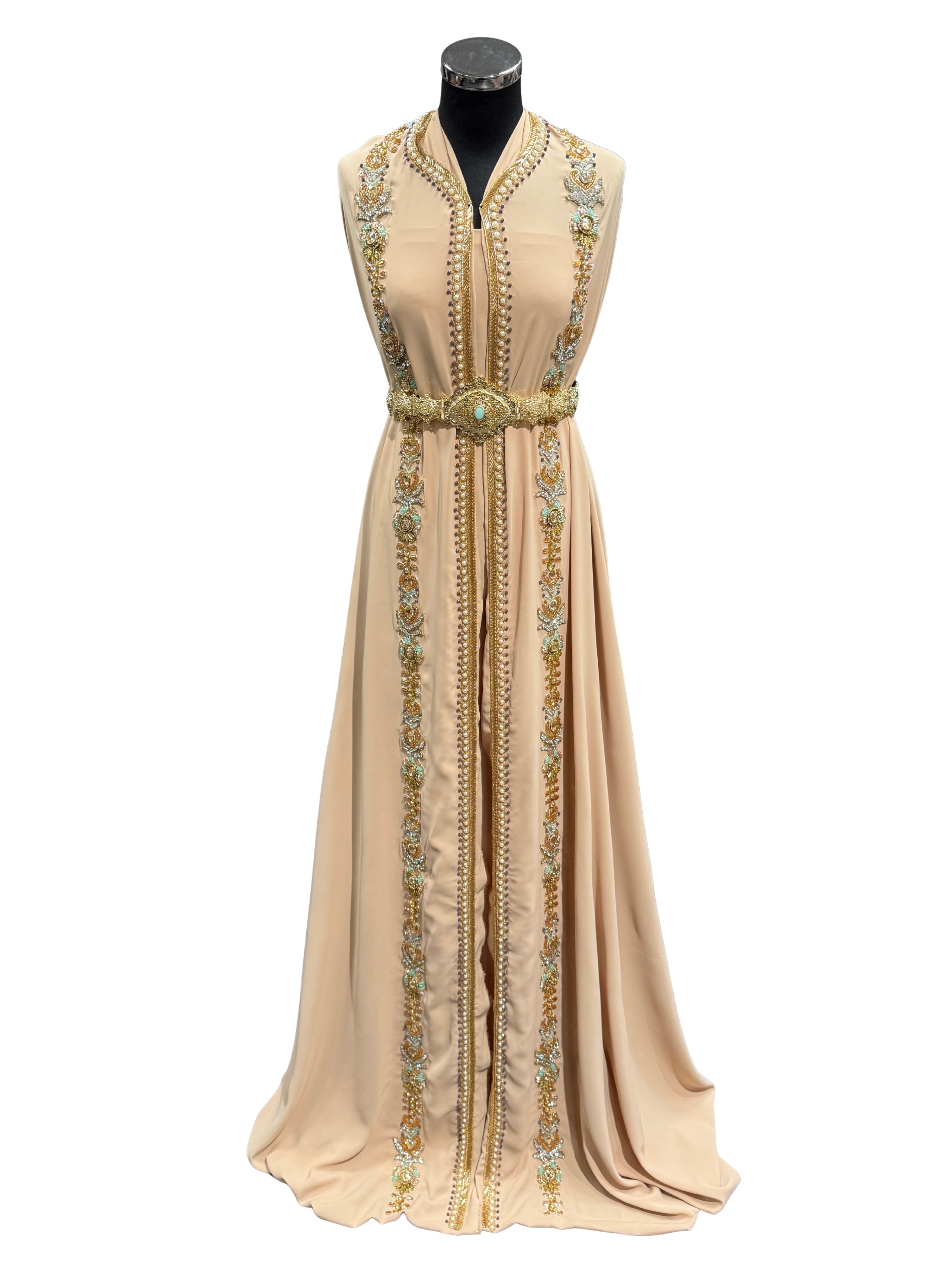 Voorkant van zandbeige takshita stof, subtiel bewerkt met kraaltjes en steentjes.