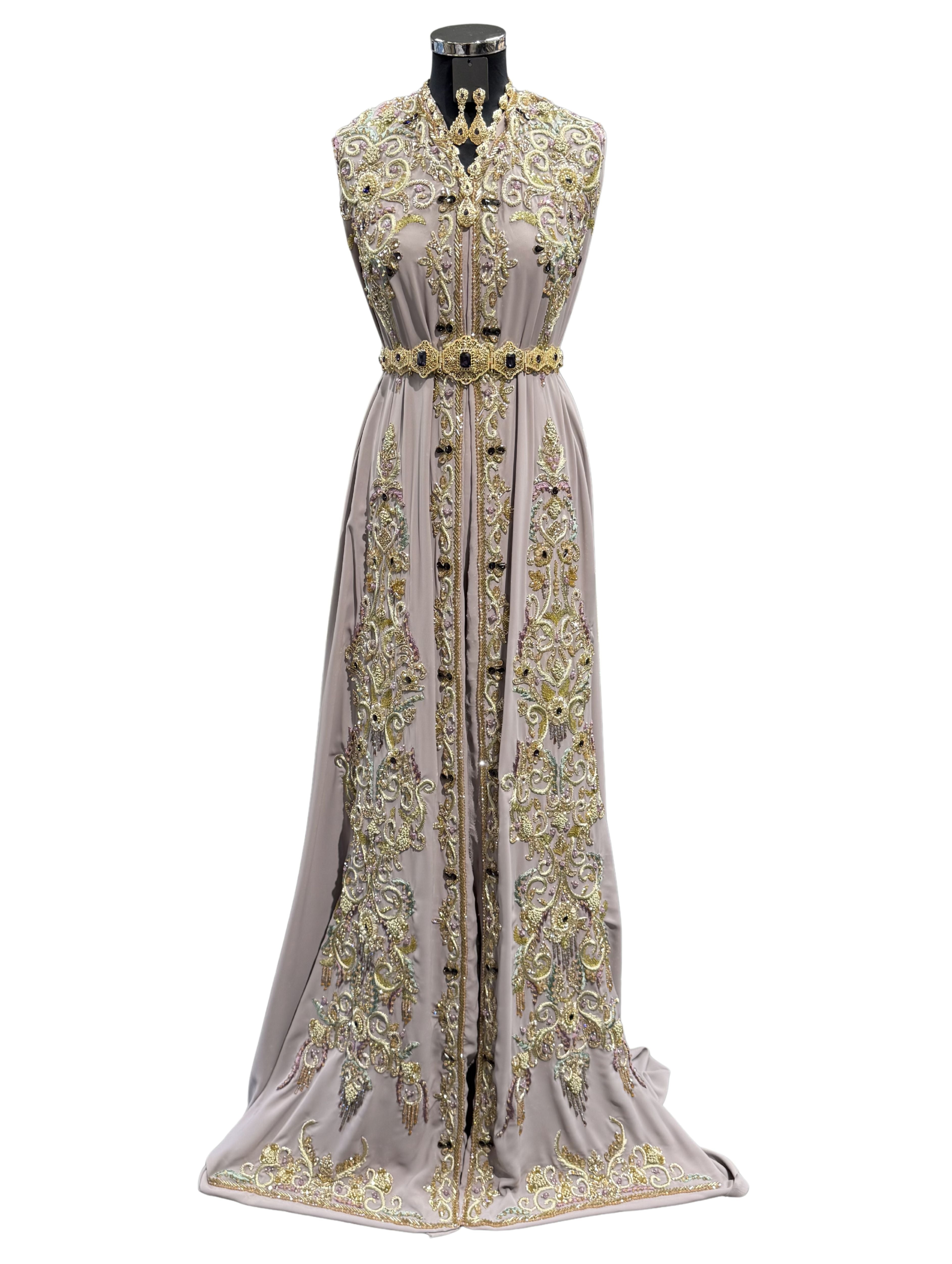 Voorkant van taupe crêpe takshita stof met goud- en groen borduurwerk, kralen en donkerpaarse stenen.