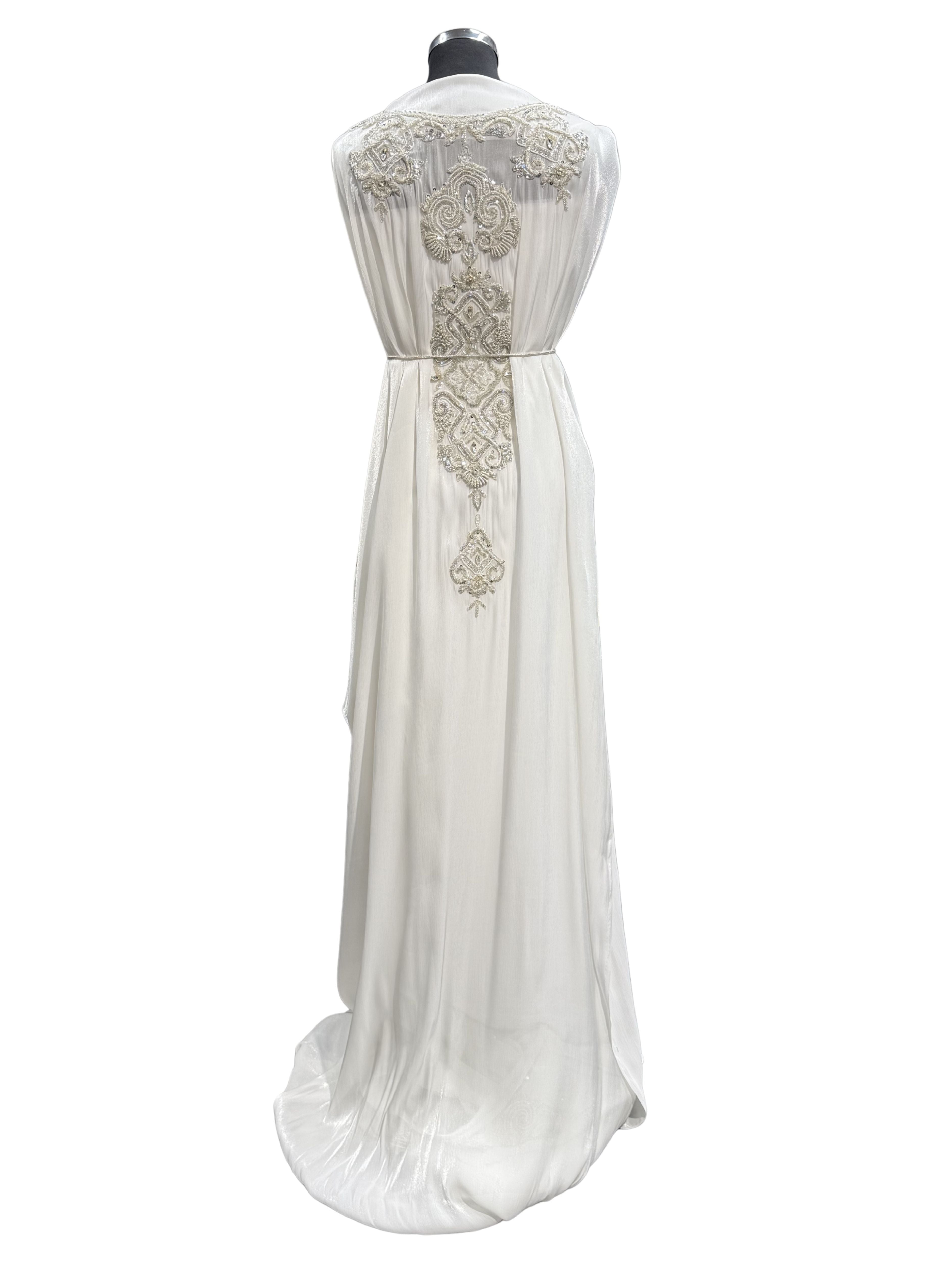 Achterkant van witte soepel vallende organza takshita stof met zilverkleurige stenen en kralen.