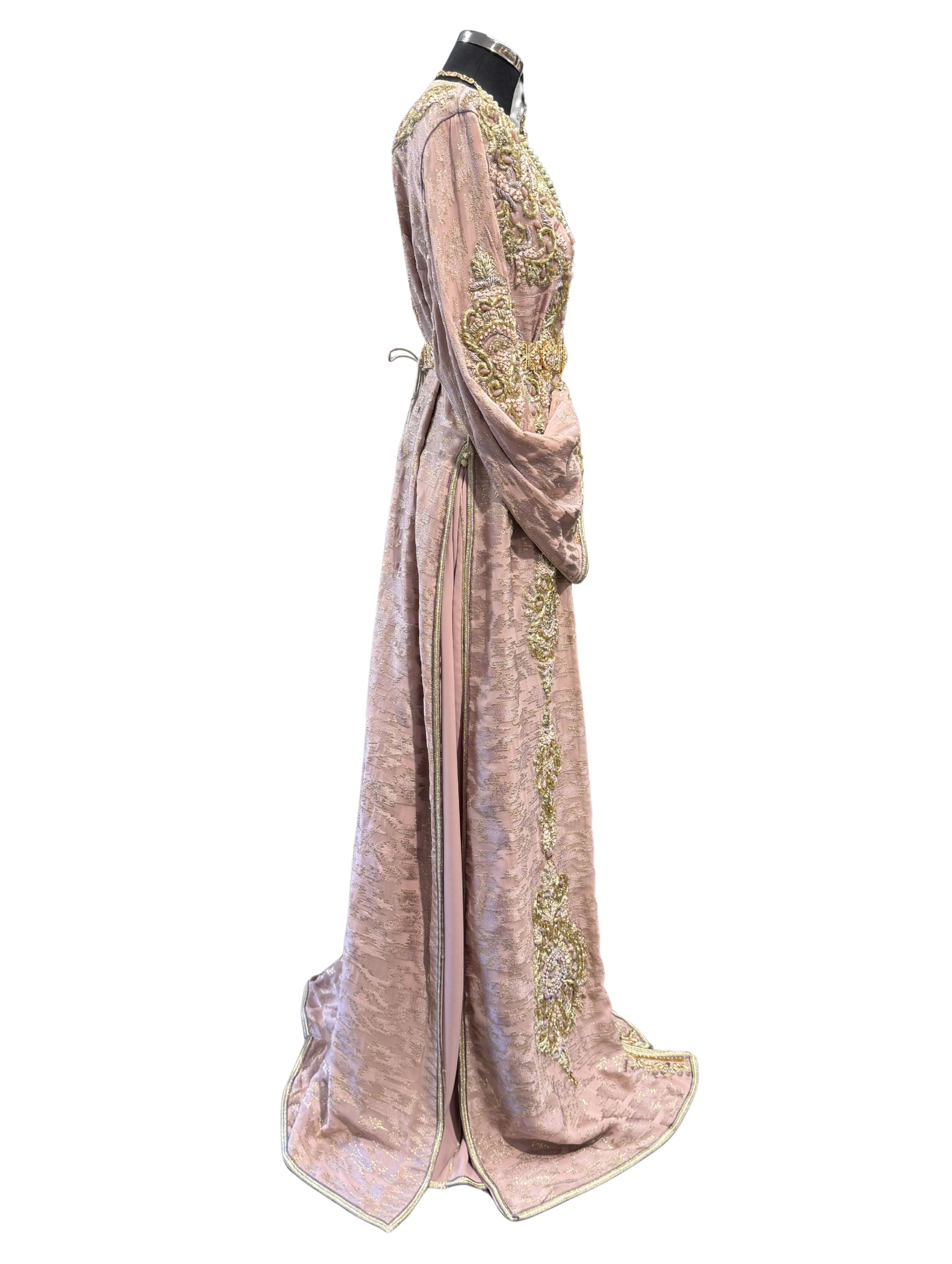 Zijkant van oudroze takshita met hoge zijsplit en gouden bewerking.