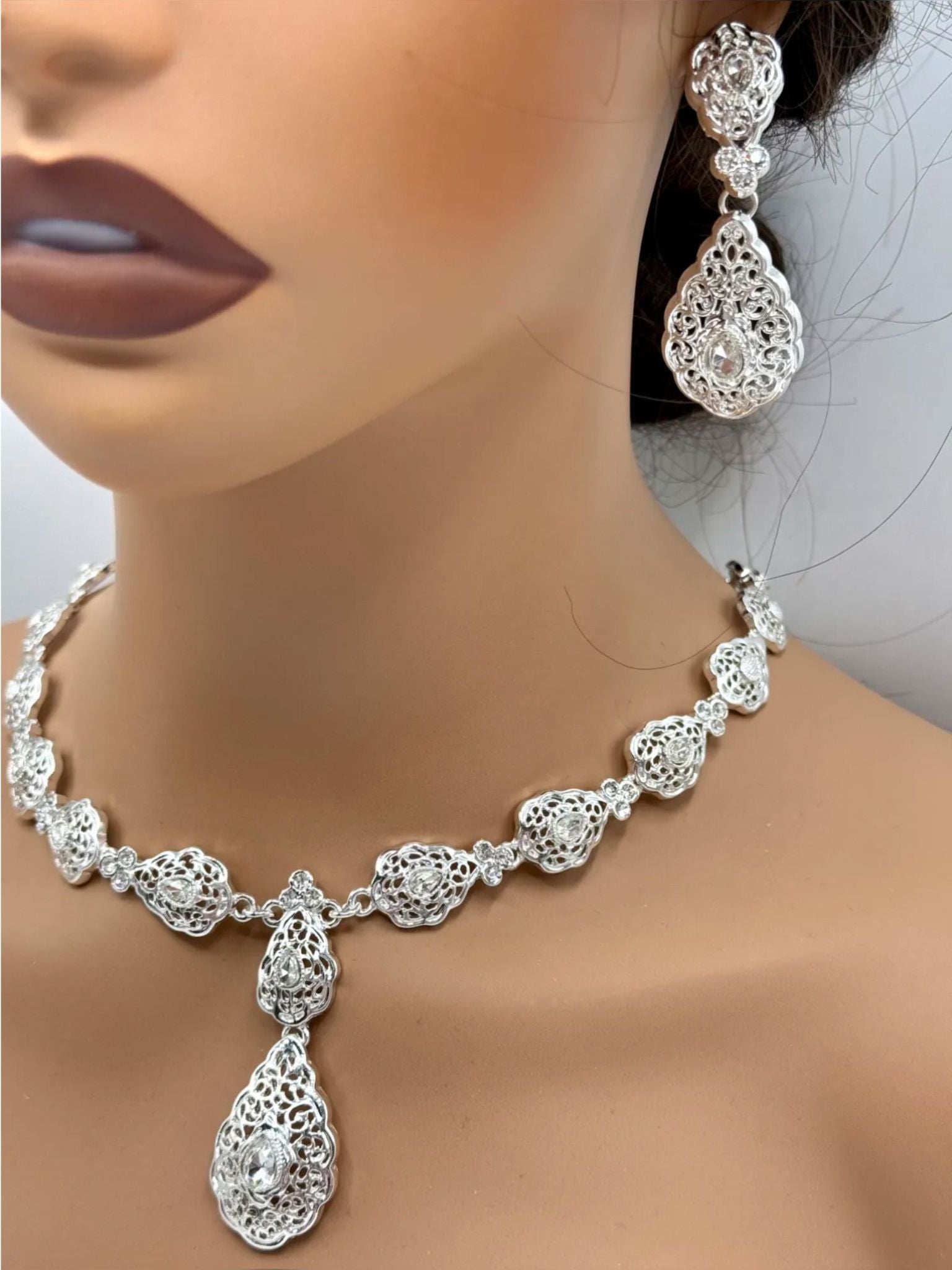 Elegante zilveren ketting met bijpassende oorbellen, versierd met fonkelende heldere stenen voor een luxe uitstraling