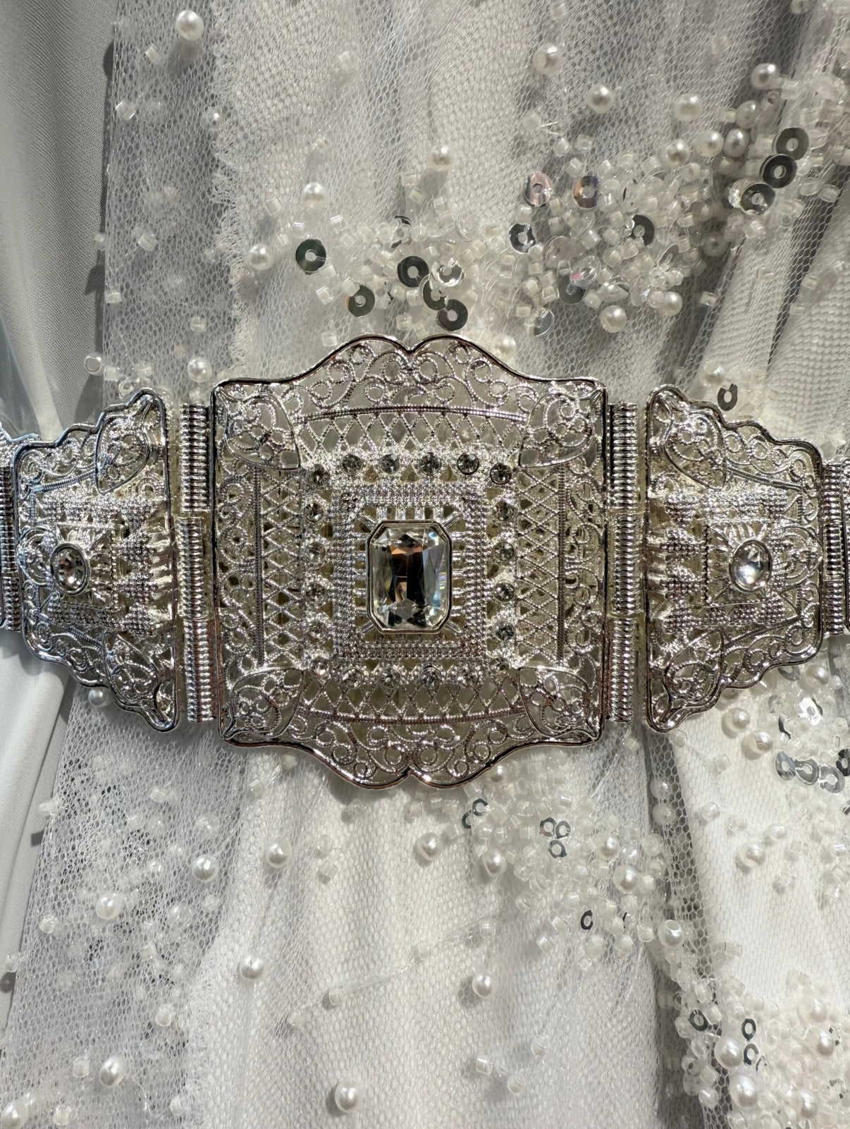 Zilveren taqlidi riem, traditionele Marokkaanse mdamma riem met heldere stenen, gedragen bij een takshita