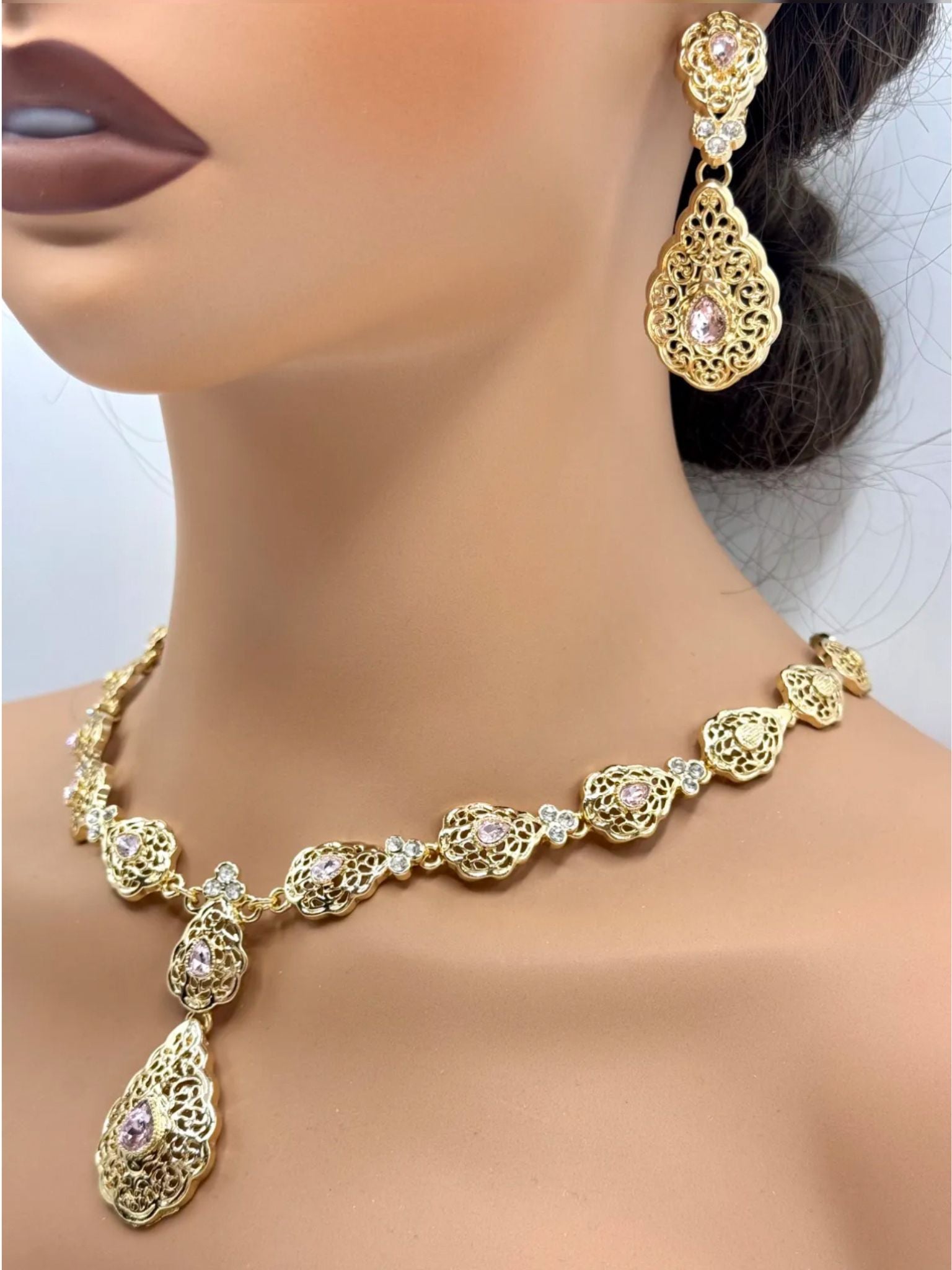 Elegante gouden ketting met bijpassende oorbellen, versierd met fonkelende roze stenen voor een luxe uitstraling
