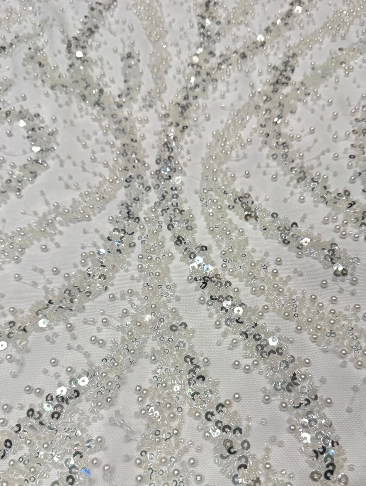 Kanten stof in de kleur wit met kralen en parels