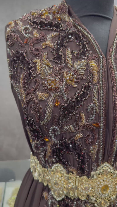 Video van donkerbruine soepel vallende crêpe stof, afgewerkt met tone-sur-tone details van kralen, stenen en velours patches.