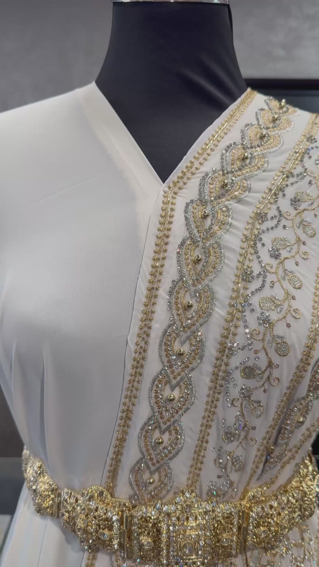 Video van crème sari stof met goud en zilver borduurwerk en donkergroene kraaltjes, waarbij de details en glans van de stof goed zichtbaar zijn. Ideaal voor luxe traditionele outfits.