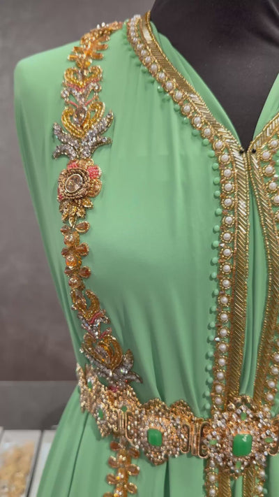 Video van aqua groene soepel vallende crêpe stof met subtiele goudkleurige versiering.