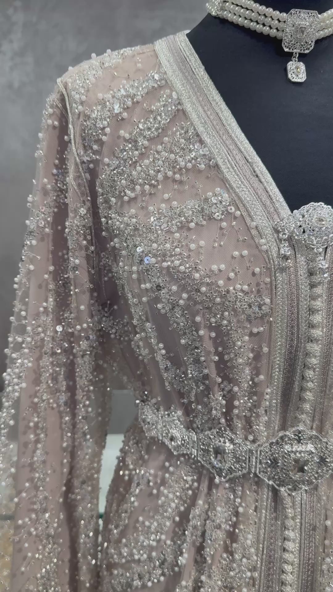 Beige takshita van kant met zilveren kralen, elegant afgewerkt voor speciale gelegenheden.