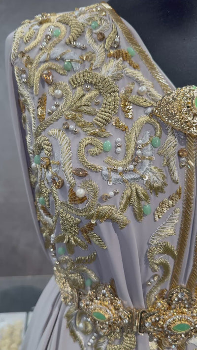 Video van grijsbeige soepel vallende crêpe stof met goudkleurig borduurwerk en mintgroene kralen.