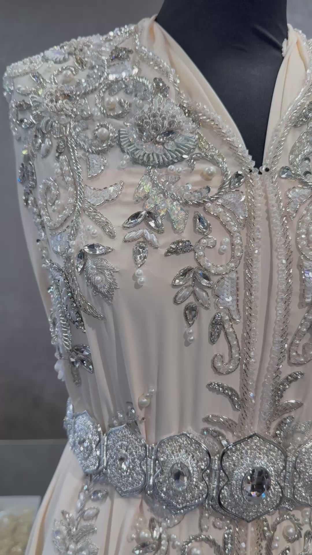 Video van ivoorcrème takshita stof met zilverkleurige bewerking, kraaltjes en steentjes.