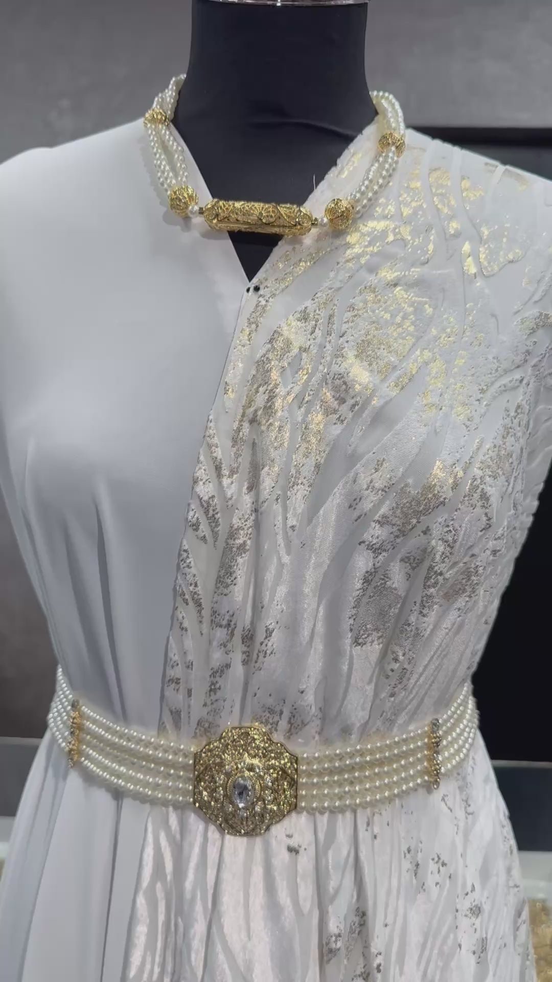 Detailvideo van velvet tlija stof in gebroken wit met gouden accenten en luxe uitstraling.