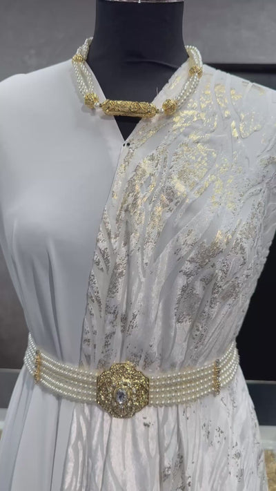 Detailvideo van velvet tlija stof in gebroken wit met gouden accenten en luxe uitstraling.