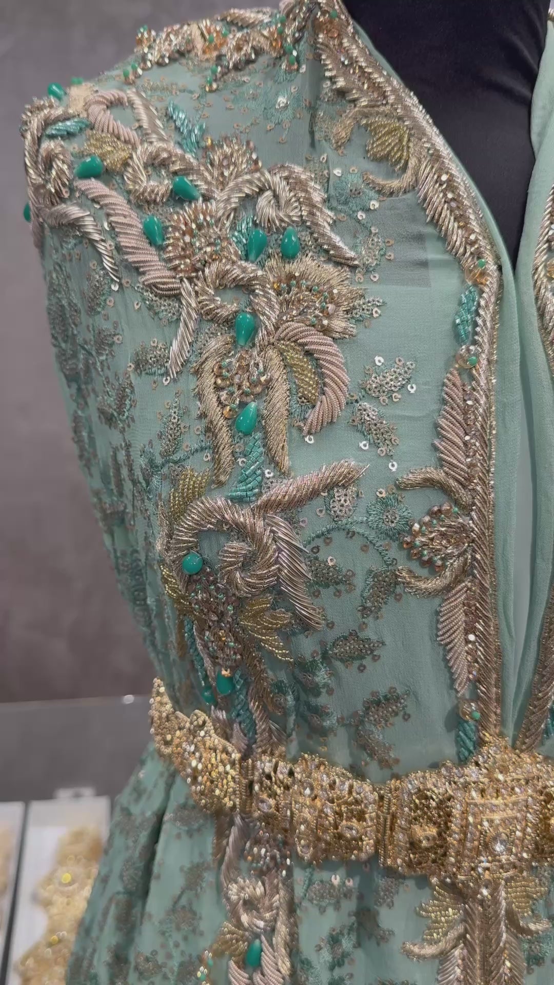 Video van zacht zeegroene transparante stof, volledig geborduurd en gevuld met pailletten, afgewerkt met goudborduurwerk en zeegroene kralen.