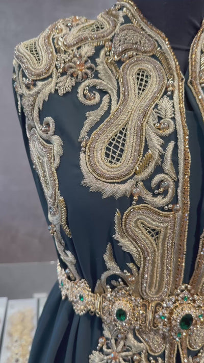 Video van donker smaragdgroene crêpe stof voor takshita waarin de gouden bewerking, guipure en de valling zichtbaar zijn.