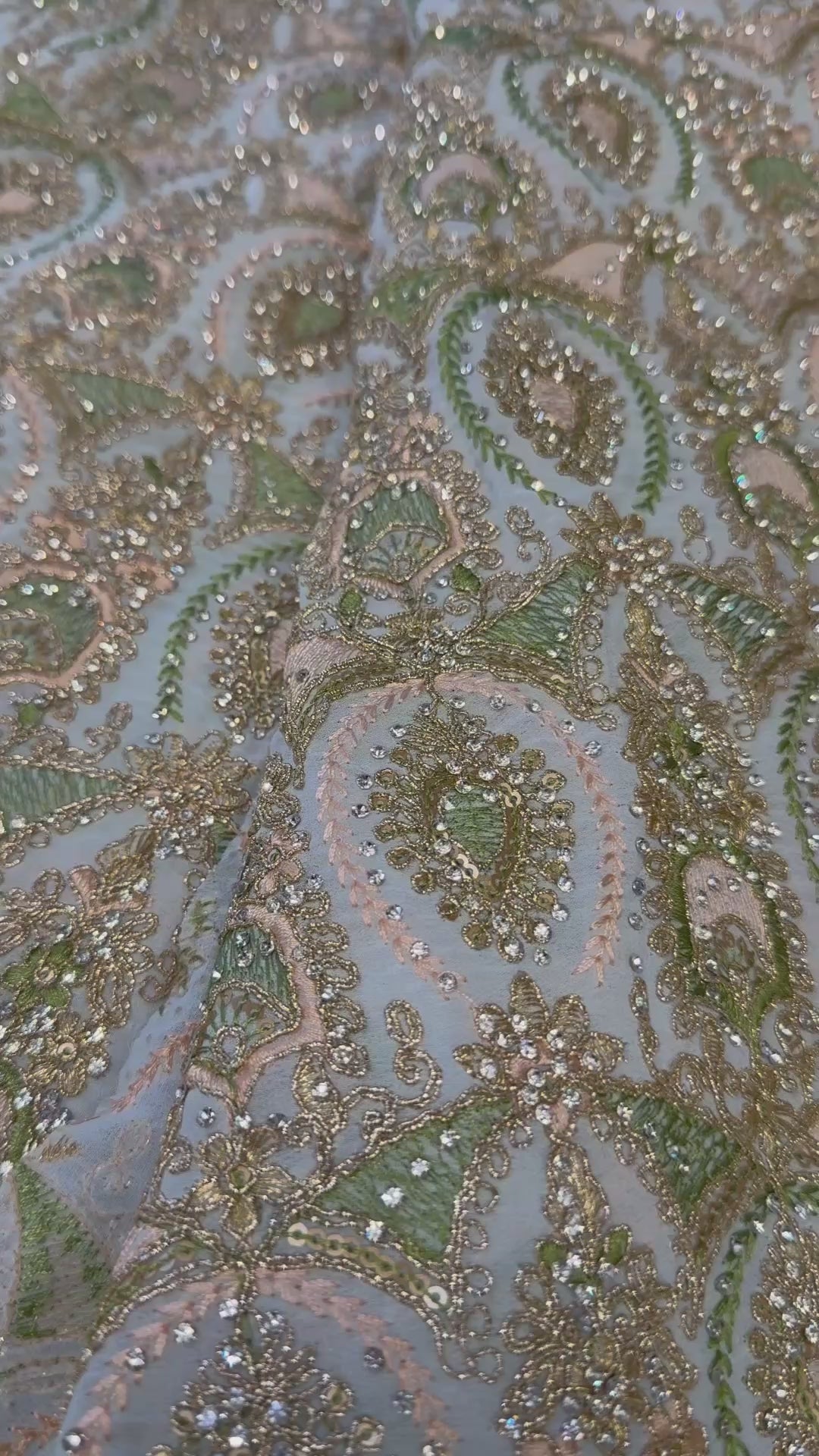 Video van lichtblauwe sari stof met pistache en poederroze borduurwerk en zilveren glassteentjes in detail