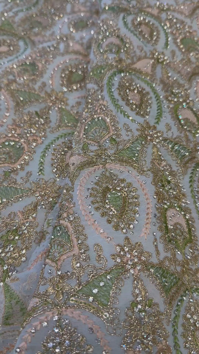 Video van lichtblauwe sari stof met pistache en poederroze borduurwerk en zilveren glassteentjes in detail
