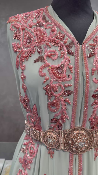 Video van mint groene soepel vallende caftan stof, afgewerkt met donkerzalmkleurig borduursel, stenen en kralen.