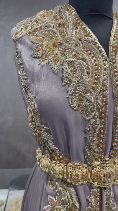 Video van grijstaupe soepel vallende organza stof met zachte glans, goudkleurig borduurwerk en kraaltjes.