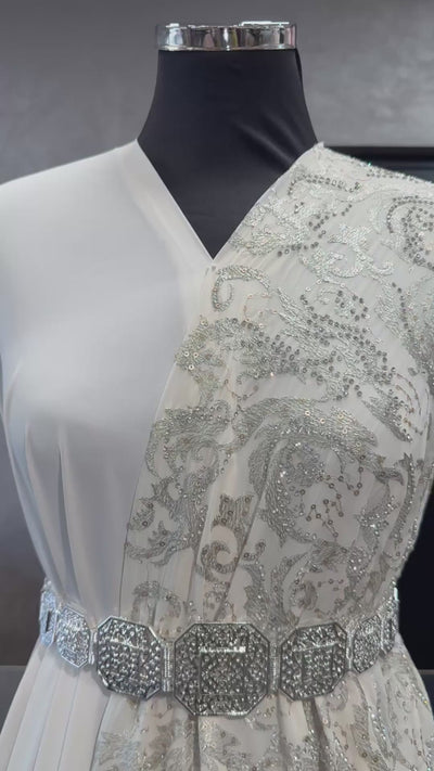 Video van crème sari stof met zilveren borduursel en steentjes, waarbij de fijne details en glans van de stof goed zichtbaar zijn. Ideaal voor elegante traditionele outfits.