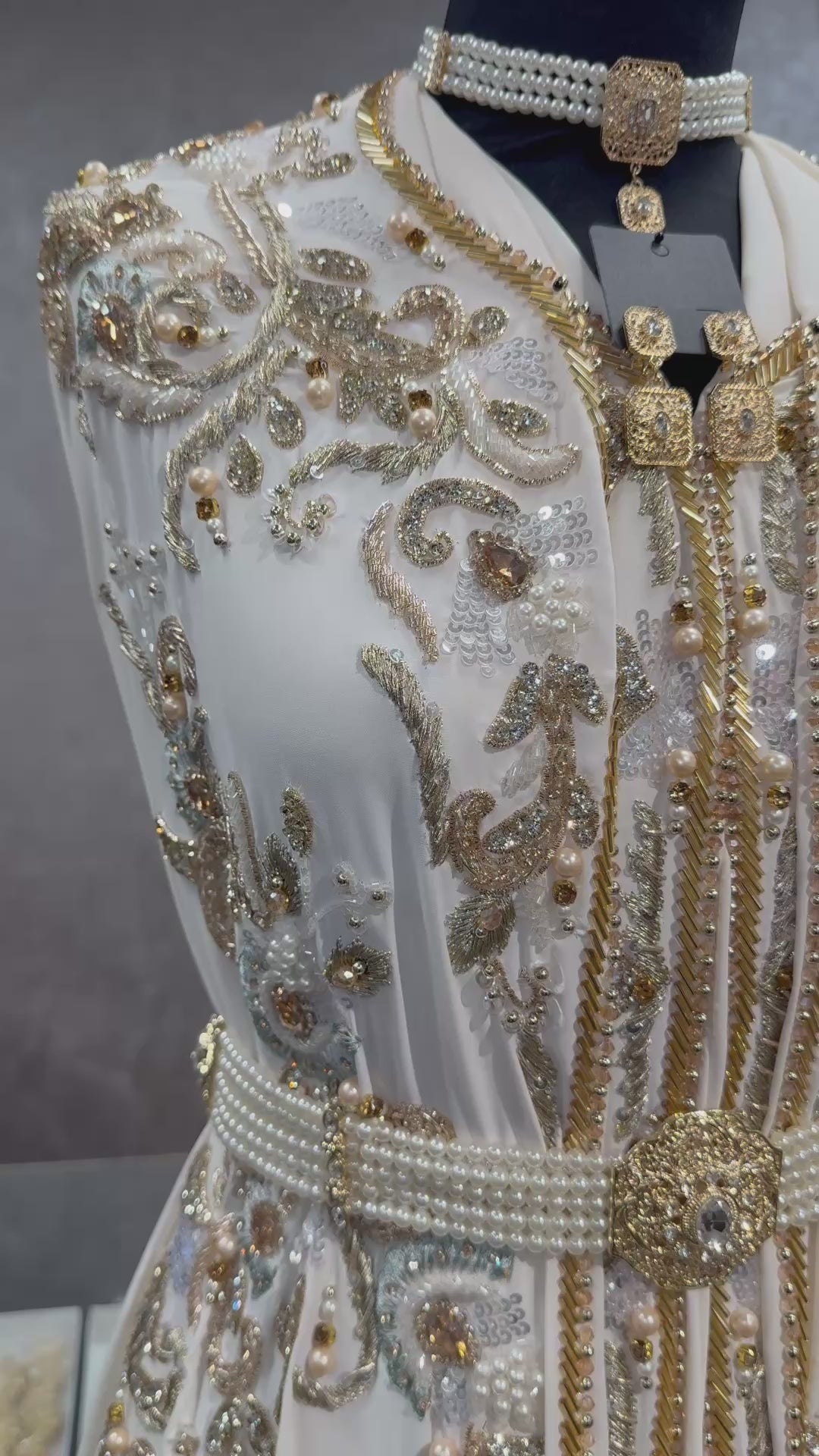 Video van crème caftan of takshita stof met parels, kralen en steentjes op boven- en onderstof.