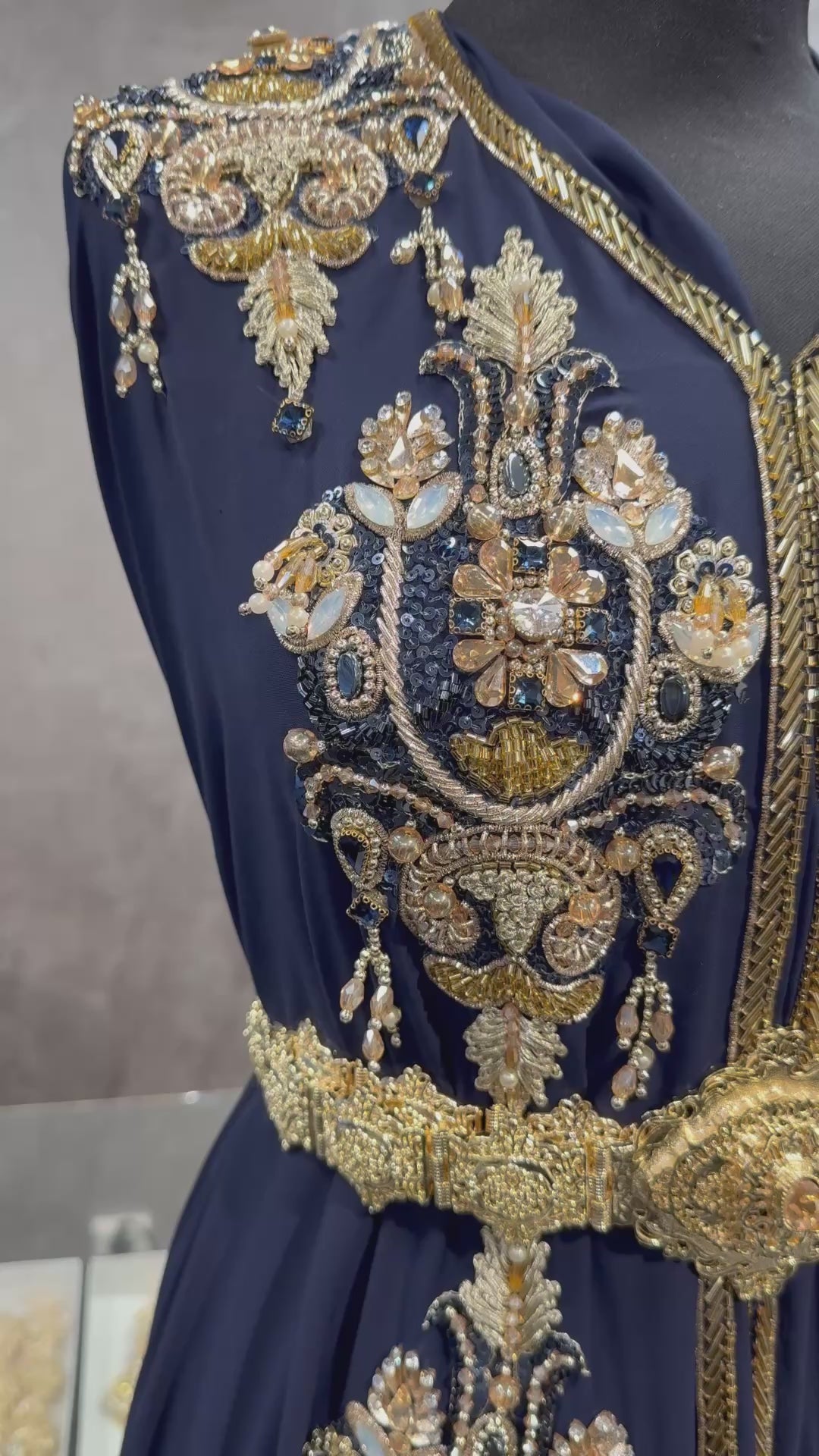 Video van donkerblauwe crêpe stof voor takshita waarin de gouden bewerking, steentjes en valling zichtbaar zijn.