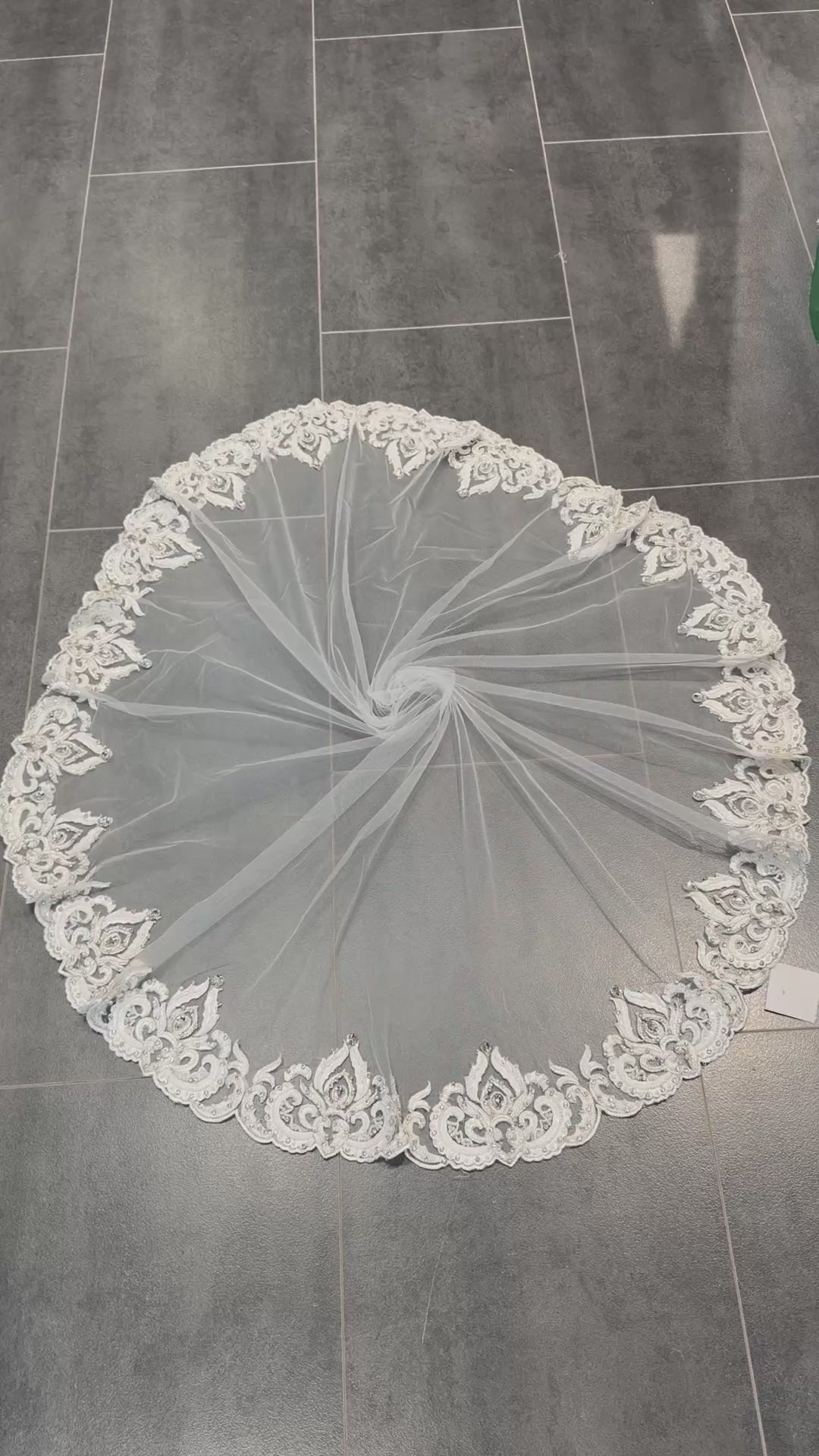 Video van ronde bruidssluier van tule in gebroken wit met geborduurde ornamentrand, parels, kralen en steentjes.