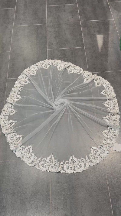 Video van ronde bruidssluier van tule in gebroken wit met geborduurde ornamentrand, parels, kralen en steentjes.