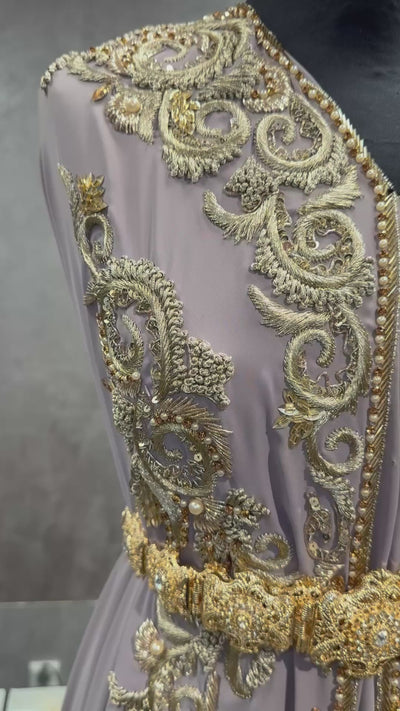 Video van taupe crêpe stof voor takshita waarin het goud borduurwerk, de valling en de stofstructuur zichtbaar zijn.