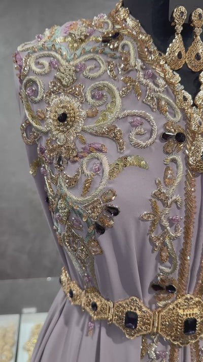 Video van soepelvallende taupe crêpe takshita stof met goud- en groen borduurwerk, kralen en donkerpaarse stenen in beweging.