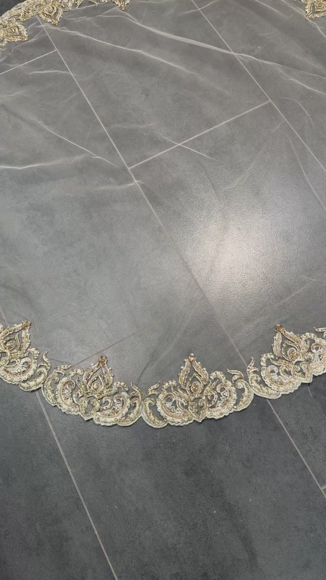 Video van beige bruidssluier met gouden borduursel, parels en steentjes, rond model van tule.