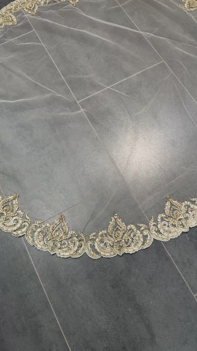 Video van beige bruidssluier met gouden borduursel, parels en steentjes, rond model van tule.