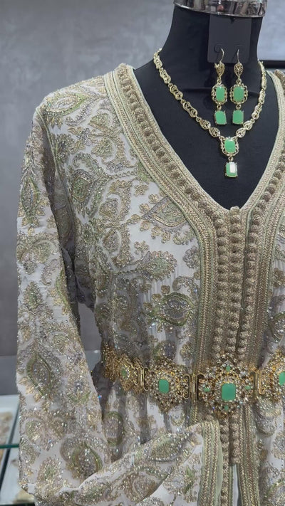 Crème kleurige ready-to-wear takshita met pistache bewerking, gouden details en pistache sfifa, geschikt voor speciale gelegenheden en traditionele Marokkaanse feesten.