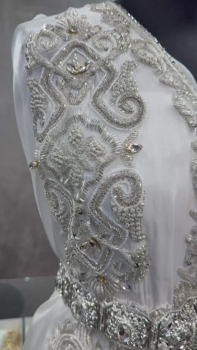 Video van witte soepel vallende organza takshita stof, afgewerkt met zilverkleurige stenen en kralen.