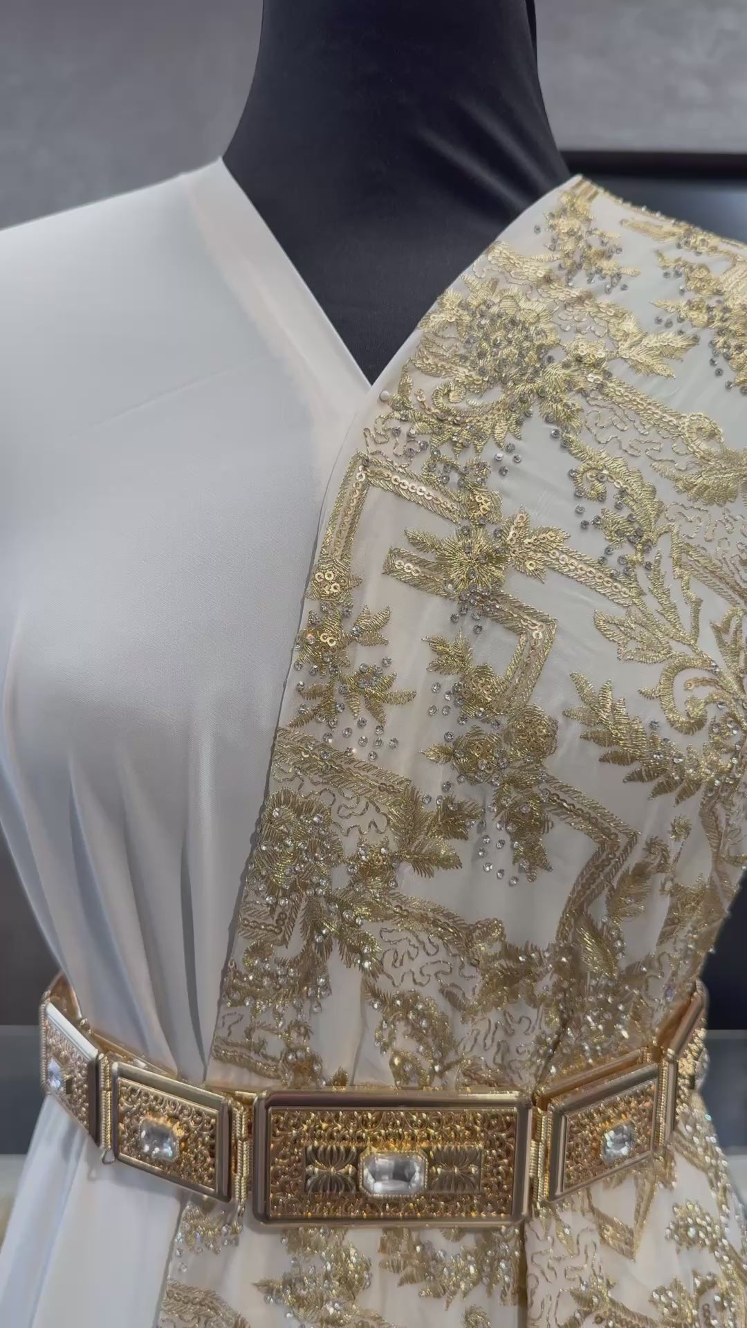 Video van crème sari stof met gouden bewerking, waarbij de details en glans van de stof goed zichtbaar zijn. Ideaal voor luxe traditionele outfits.