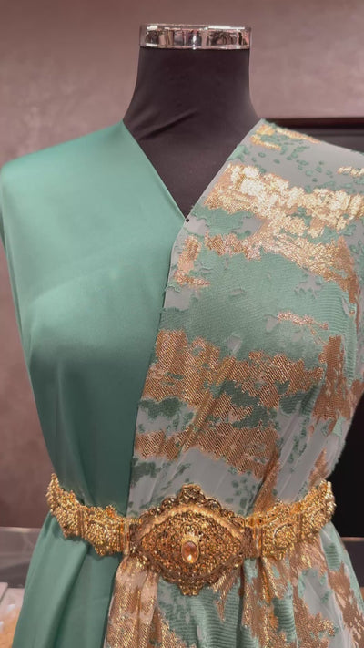 Detailvideo van de turquoise tlija stof met close-up van structuur, kleur en afwerking, geschikt voor traditionele kleding zoals takshita en dirac.